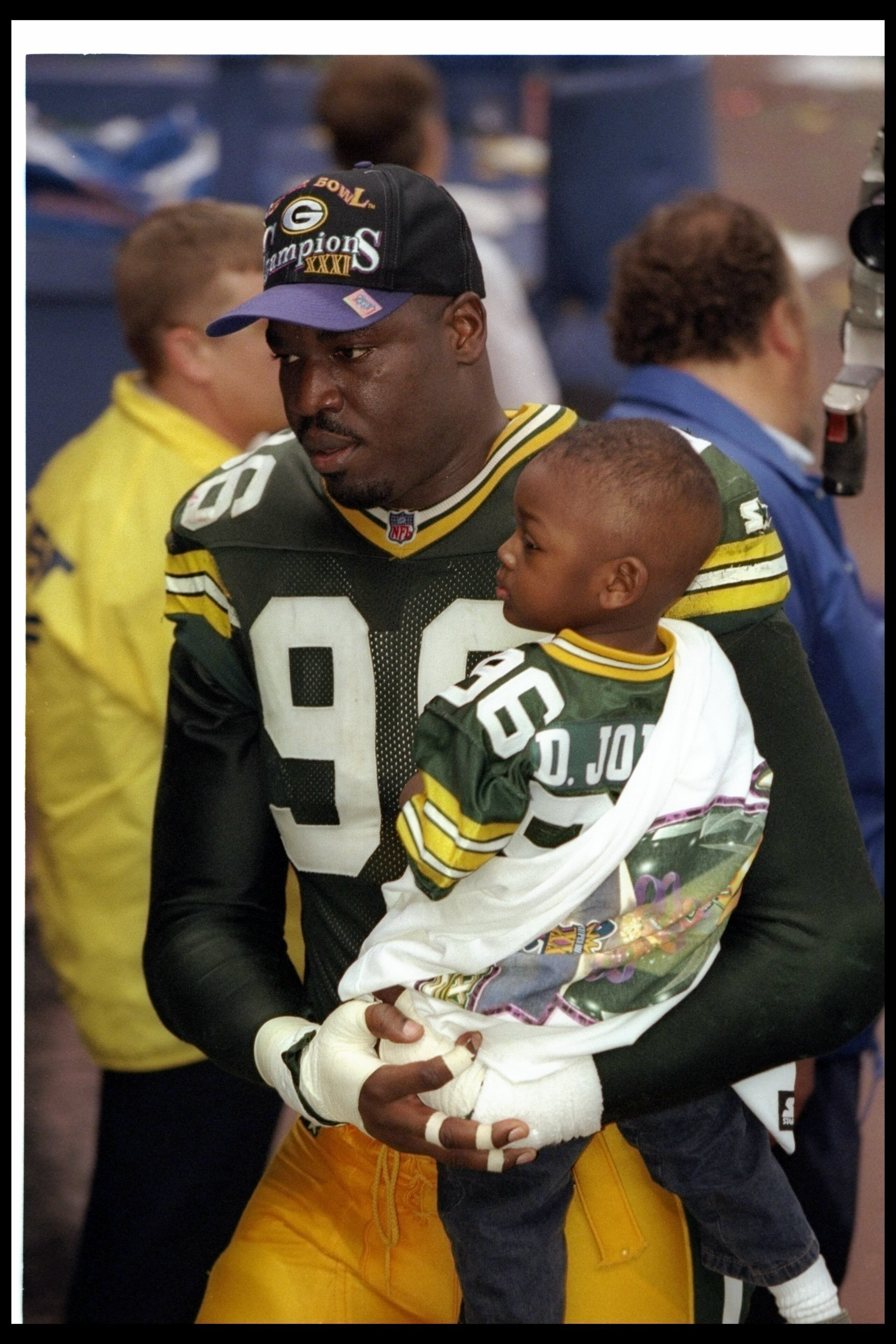 26 Jan 1997: Defensive lineman Sean Jones of the Green Bay Packers celebrates with his son after Super Bowl XXXI against the New England Patriots at the Superdome in New Orleans, Louisiana. The Packers won the game, 35-21.