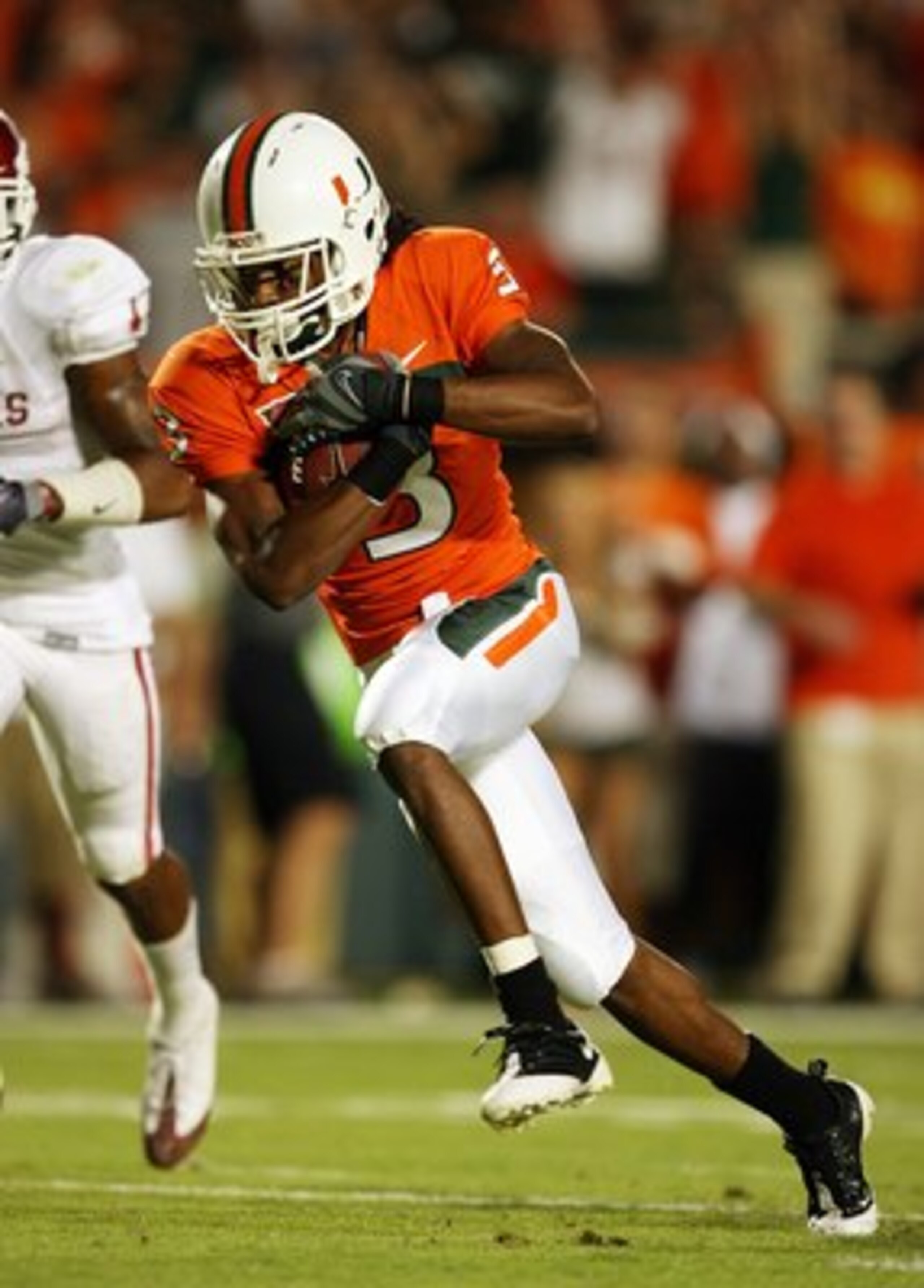 MIAMI GARDENS, FL - OCTOBER 03:  Wide receiver Travis Benjamin #3 of the Miami Hurricanes looks for room to run against the Oklahoma Sooners at Land Shark Stadium on October 3, 2009 in Miami Gardens, Florida. Miami defeated Oklahoma 21-20.  (Photo by Doug