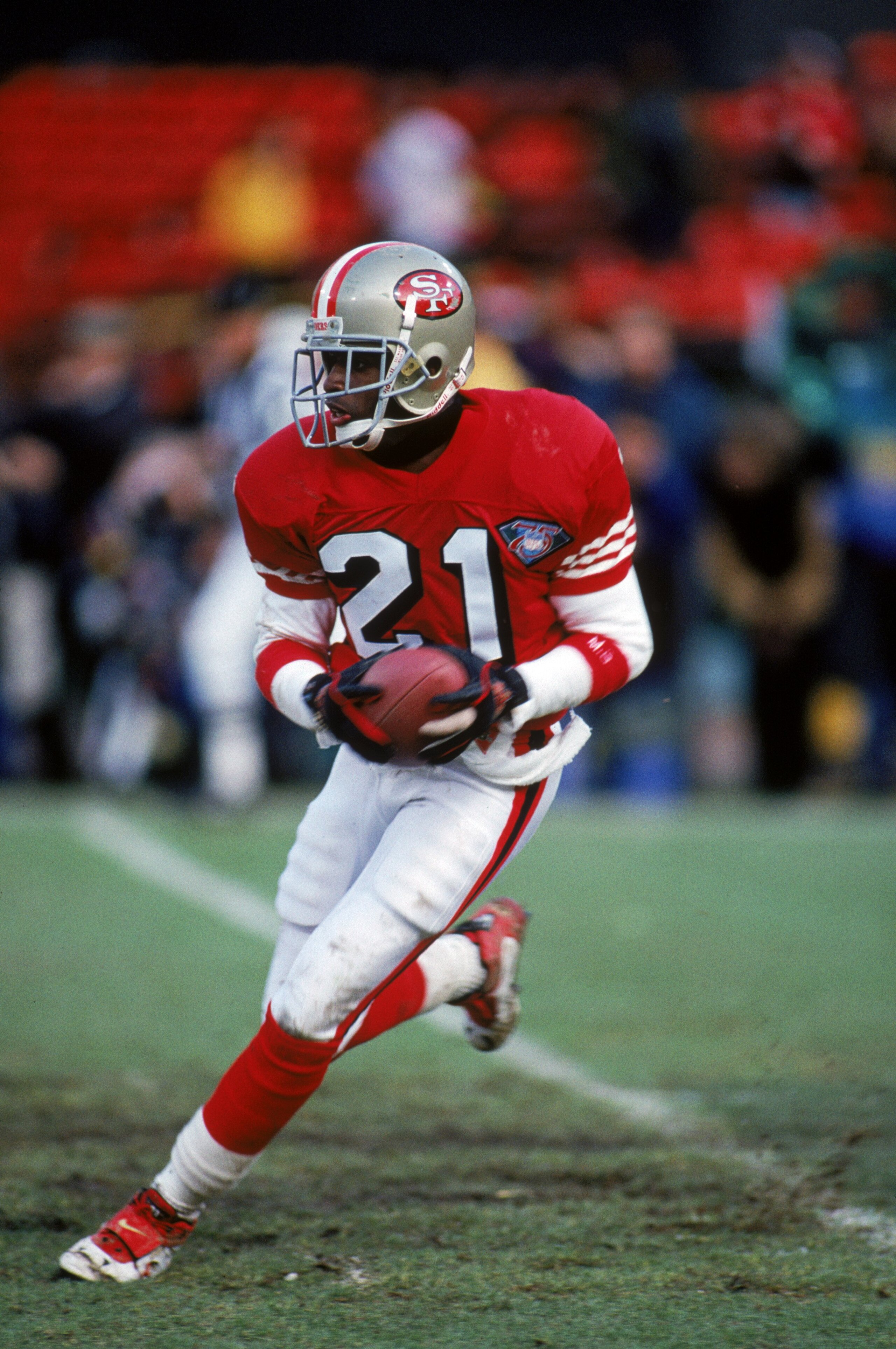 SAN FRANCISCO - JANUARY 15:  Cornerback Deion Sanders #21 of the San Francisco 49ers runs with the ball during the 1993 NFC Championship game against the New York Giants at Candlestick Park on January 15, 1994 in San Francisco, California.  The 49ers won 