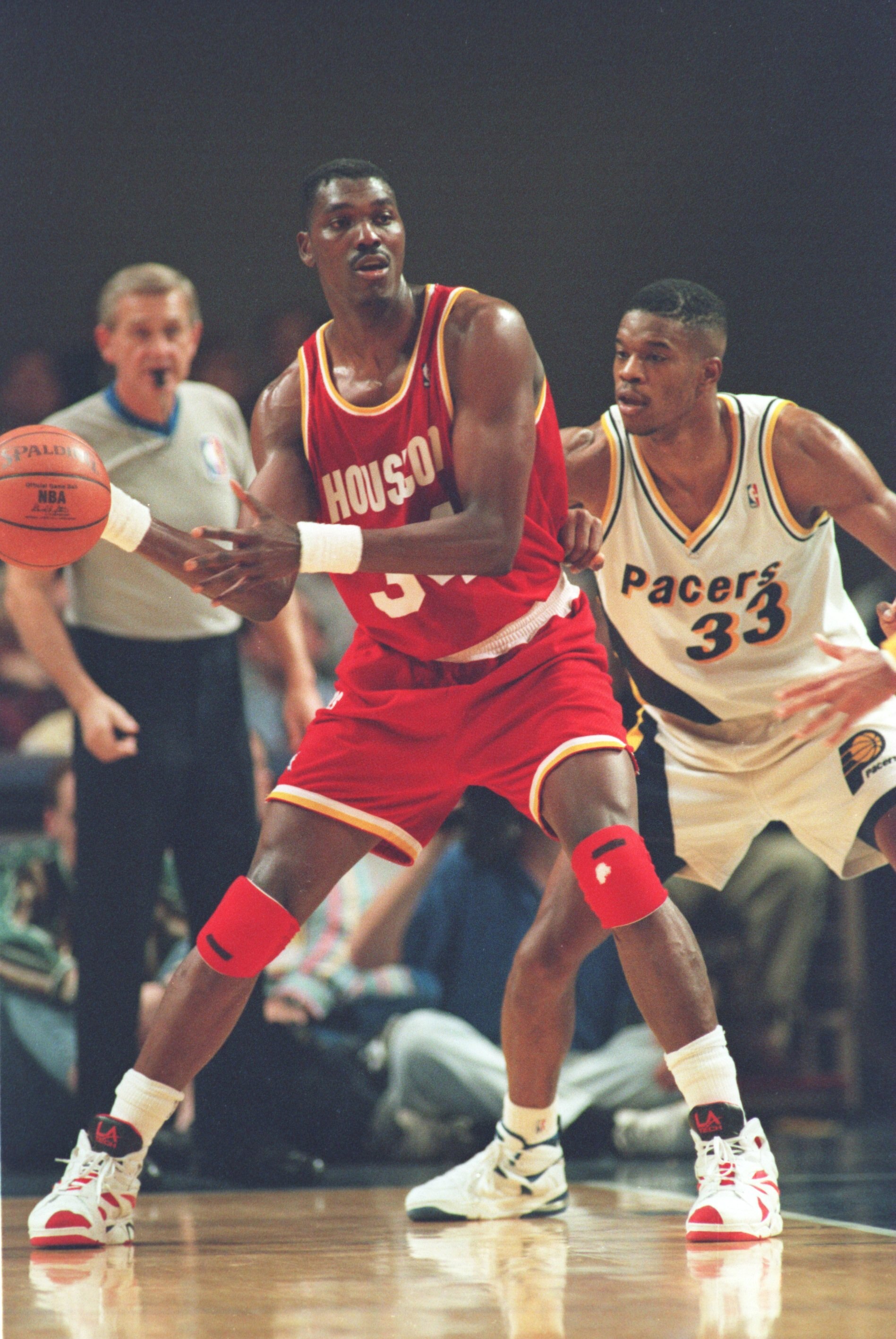 INDIANAPOLIS - NOVEMBER 9: Center Hakeem Olajuwon #34 of the Houston Rockets backs into Antonio Davis #33 of the Indiana Pacers in an attempt to gain post position during their game on November 9, 1994 at Market Square Arena in Indianapolis, Indiana. The