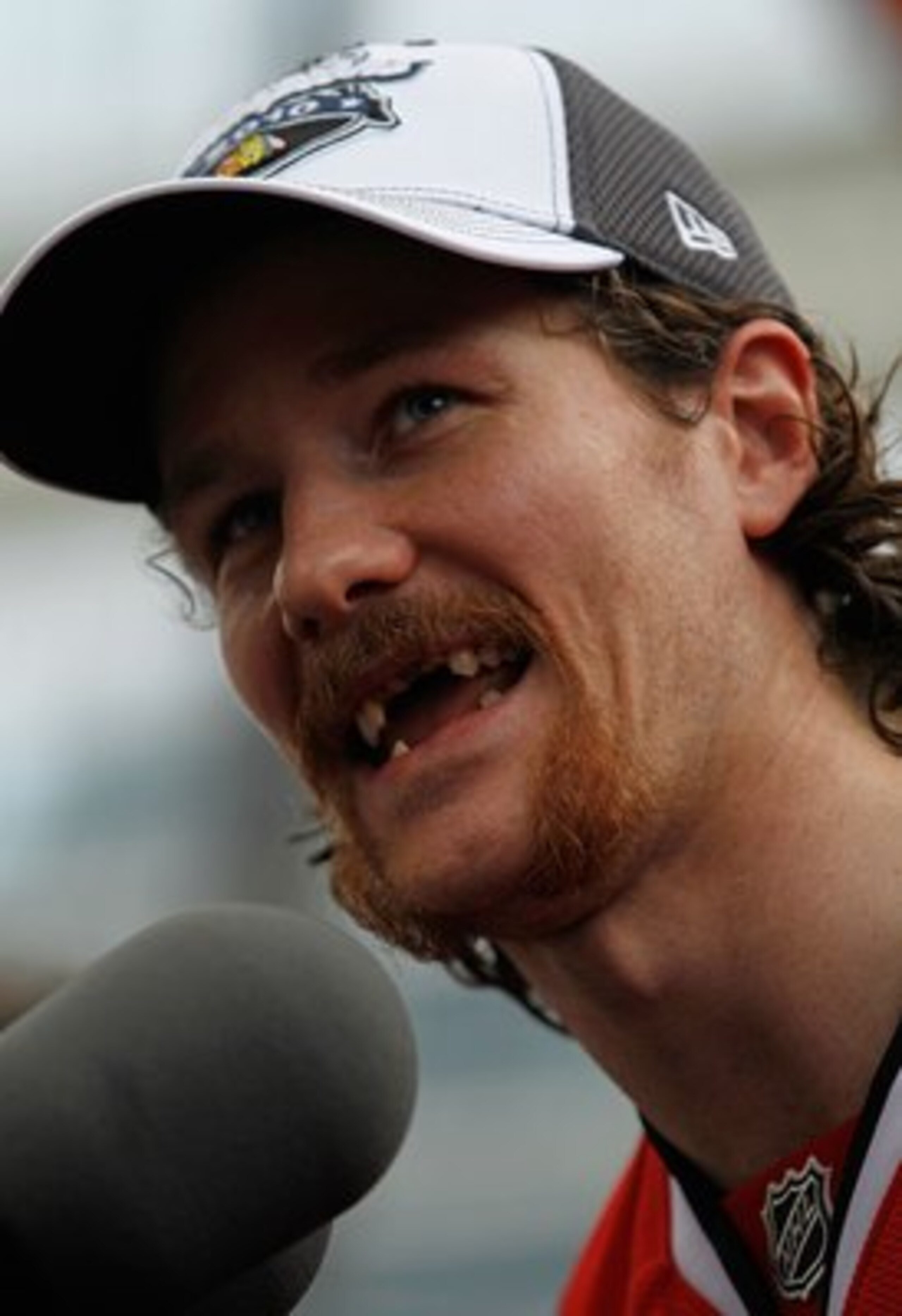 CHICAGO - JUNE 11: Duncan Keith #2, who lost seven teeth during the Stanley Cup playoffs after being hit in the mouth with a puck, speaks to the crowd during the Chicago Blackhawks Stanley Cup victory parade and rally on June 11, 2010 in Chicago, Illinois