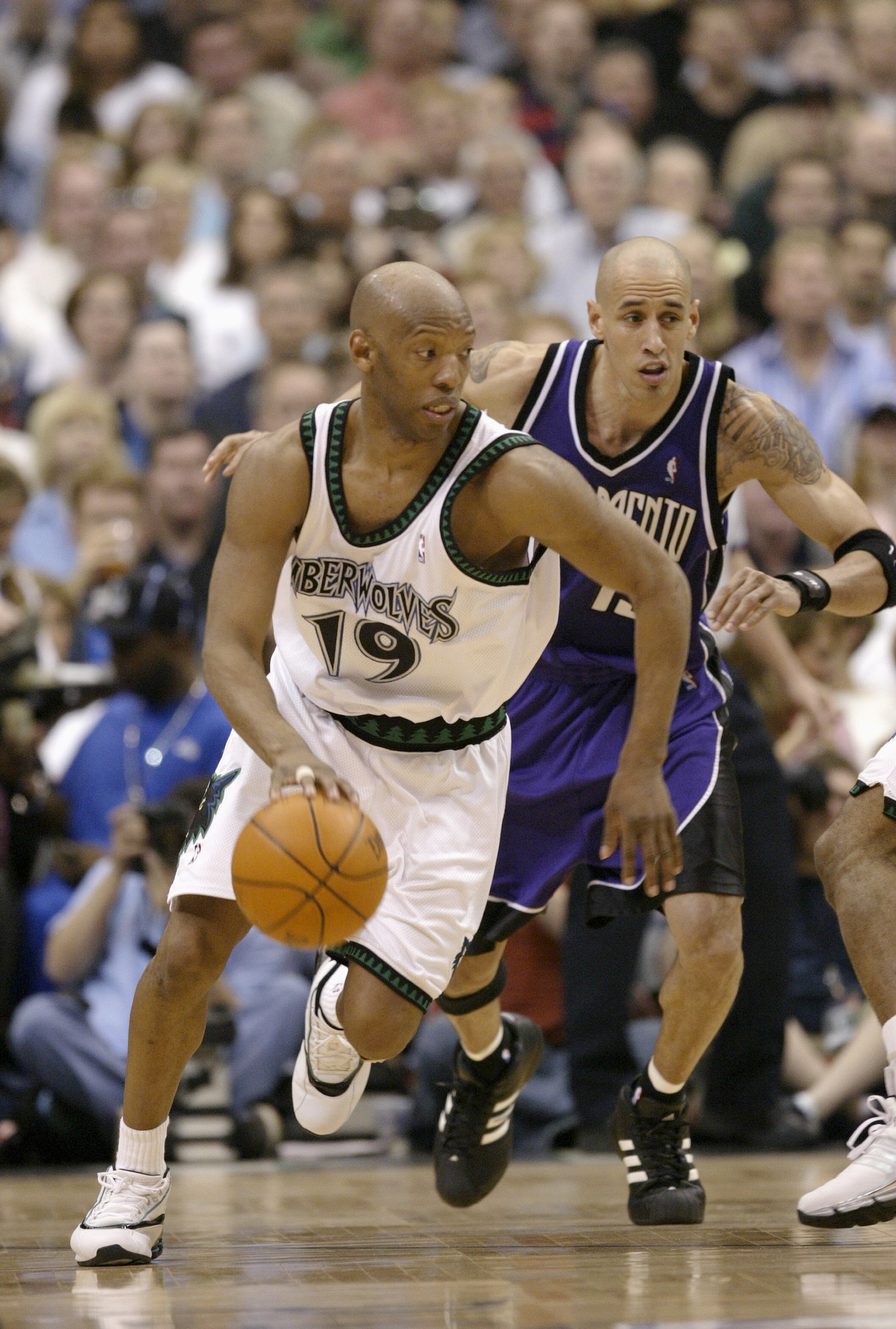 MINNEAPOLIS - MAY 8:  Sam Cassell #19 of the Minnesota Timberwolves advances the ball on the dribble as Doug Christie #13 of the Sacramento Kings gives chase in Game Two of the Western Conference Semifinals during the 2004 NBA Playoffs on May 8, 2004 at t