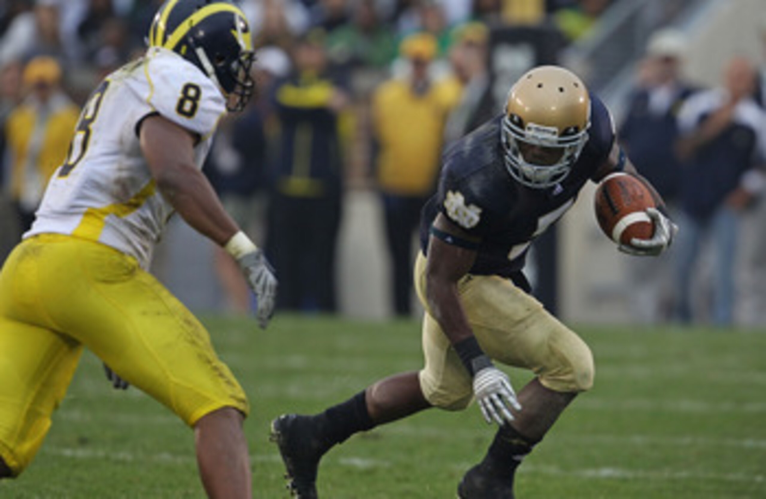 SOUTH BEND, IN - SEPTEMBER 11: Armando Allen, Jr. #5 of the Notre Dame Fighting Irish runs as Jonas Mouton #8 of the Michigan Wolverines closes in at Notre Dame Stadium on September 11, 2010 in South Bend, Indiana. Michigan defeated Notre Dame 28-24. (Pho