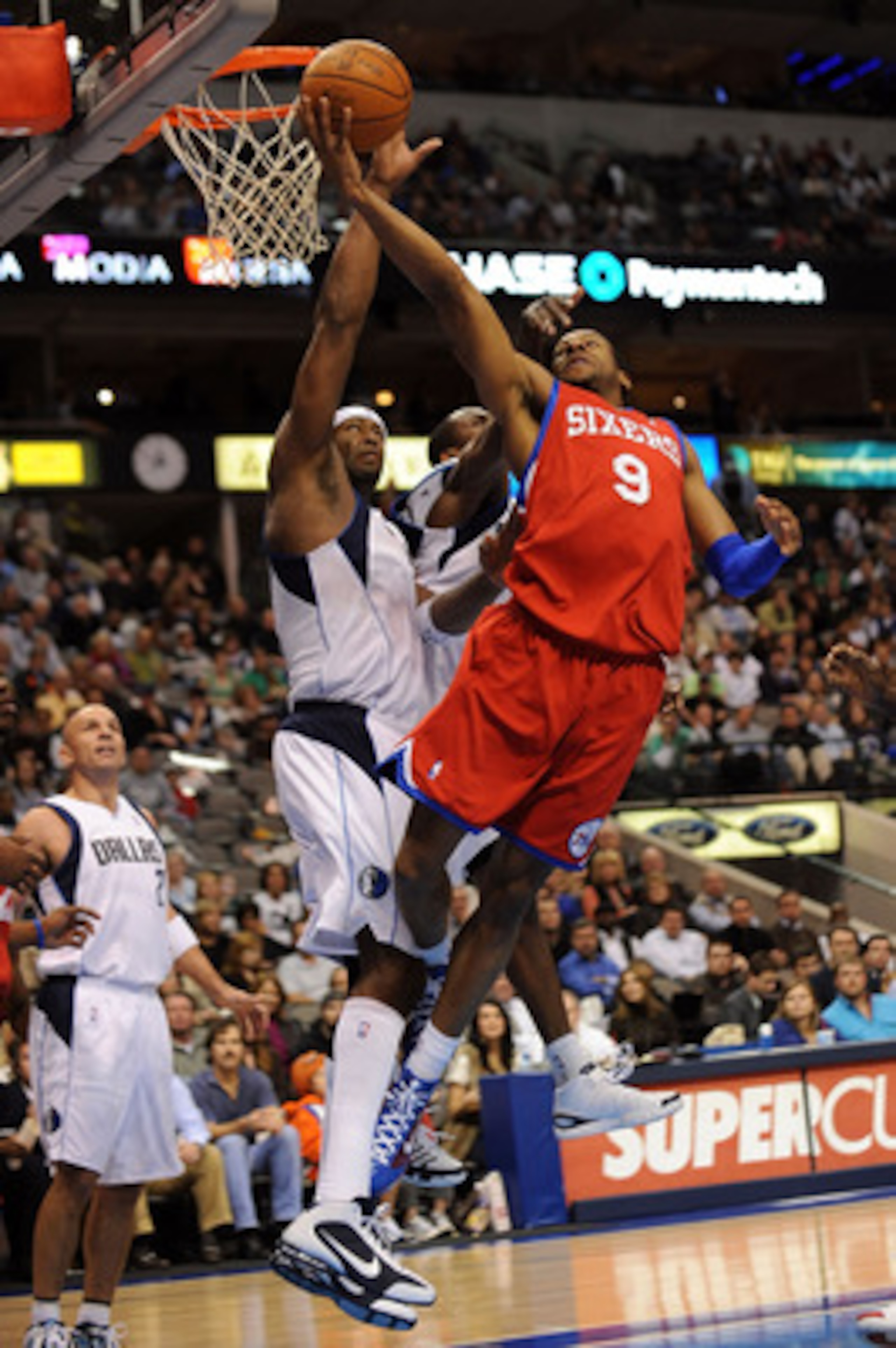 DALLAS - NOVEMBER 30:  Guard Andre Iguodala #9 of the Philadelphia 76ers takes a shot against Erick Dampier #25 of the Dallas Mavericks on November 30, 2009 at American Airlines Center in Dallas, Texas.  NOTE TO USER: User expressly acknowledges and agree