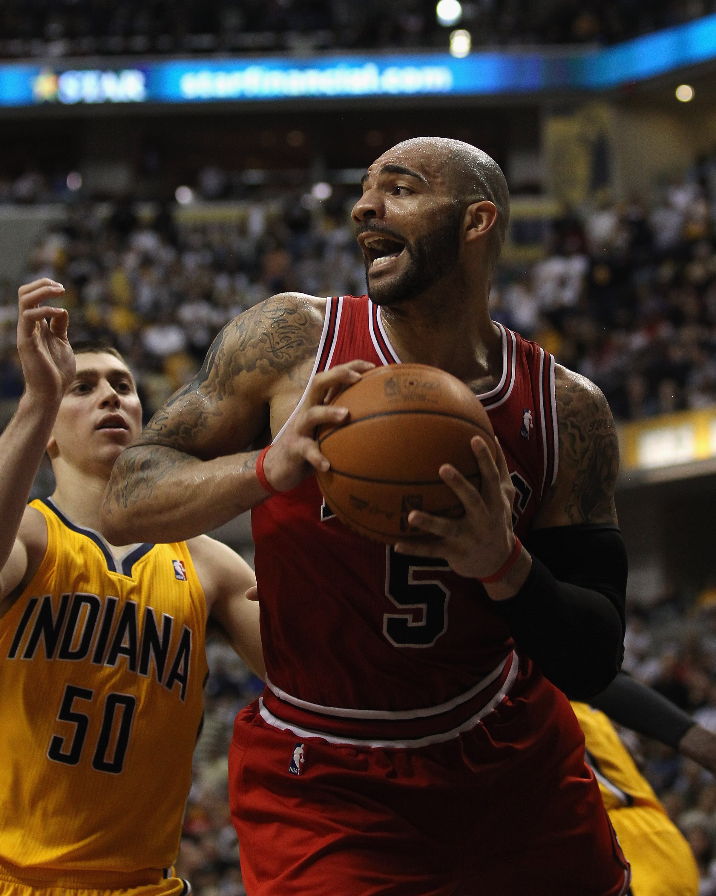 INDIANAPOLIS, IN - APRIL 23: Carlos Boozer #5 of the Chicago Bulls grabs a rebound in front of Tyler Hansbrough #50 of the Indiana Pacers in Game Four of the Eastern Conference Quarterfinals in the 2011 NBA Playoffs at Conseco Fieldhouse on April 23, 2011