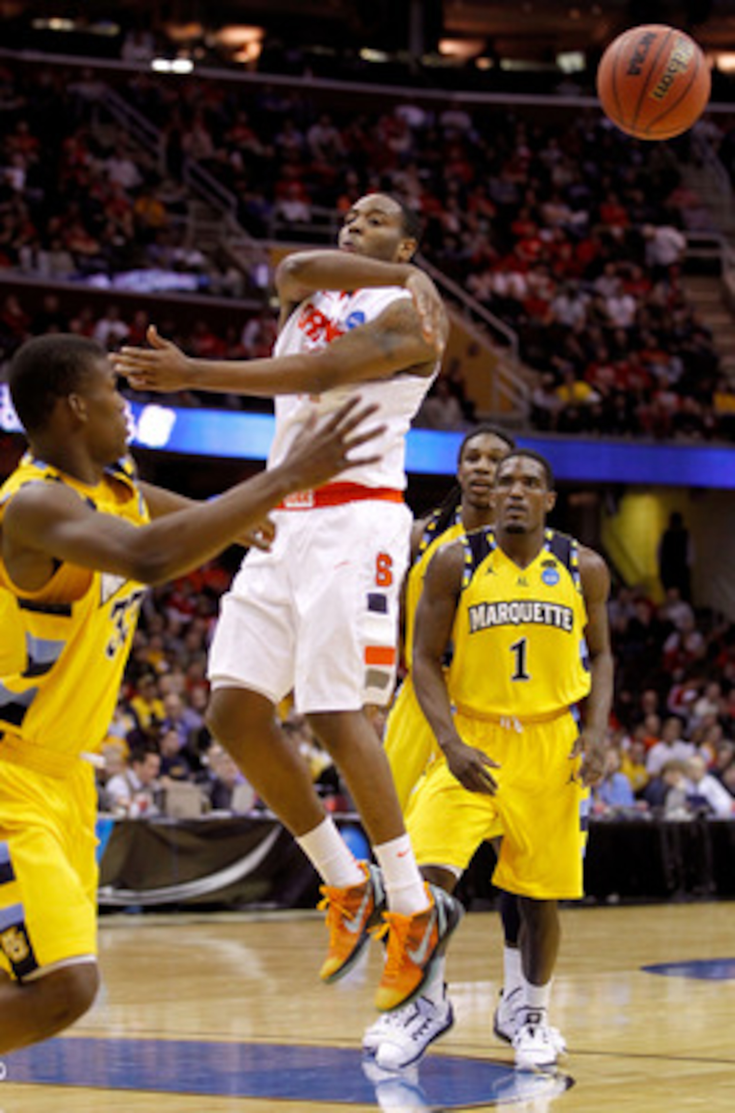 CLEVELAND, OH - MARCH 20: Scoop Jardine #11 of the Syracuse Orange makes a no look pass as Jimmy Butler #33 and Darius Johnson-Odom #1 of the Marquette Golden Eagles look on during the third of the 2011 NCAA men's basketball tournament at Quicken Loans Ar