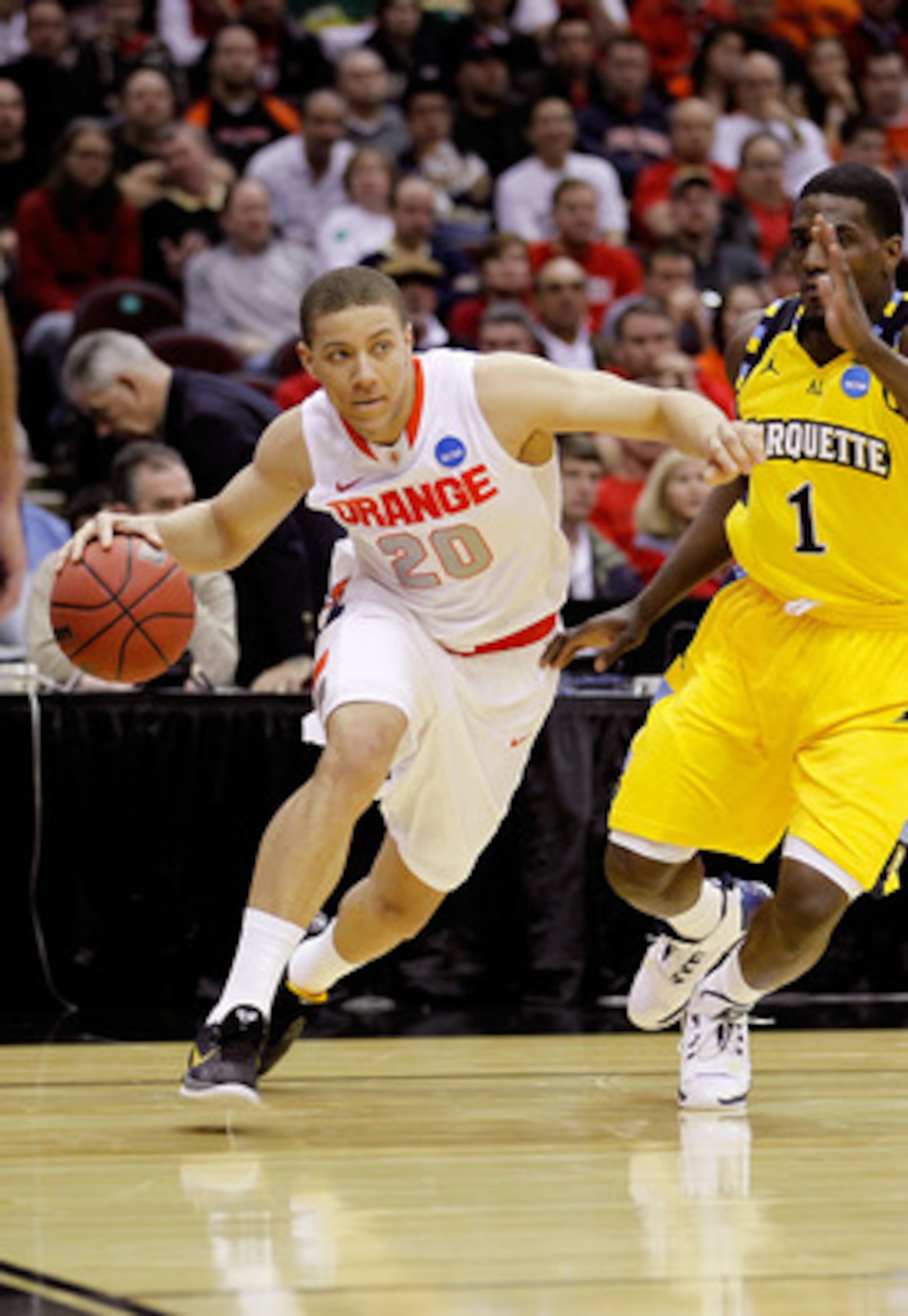 CLEVELAND, OH - MARCH 20: Brandon Triche #20 of the Syracuse Orange dribbles around Darius Johnson-Odom #1 of the Marquette Golden Eagles during the third of the 2011 NCAA men's basketball tournament at Quicken Loans Arena on March 20, 2011 in Cleveland, 