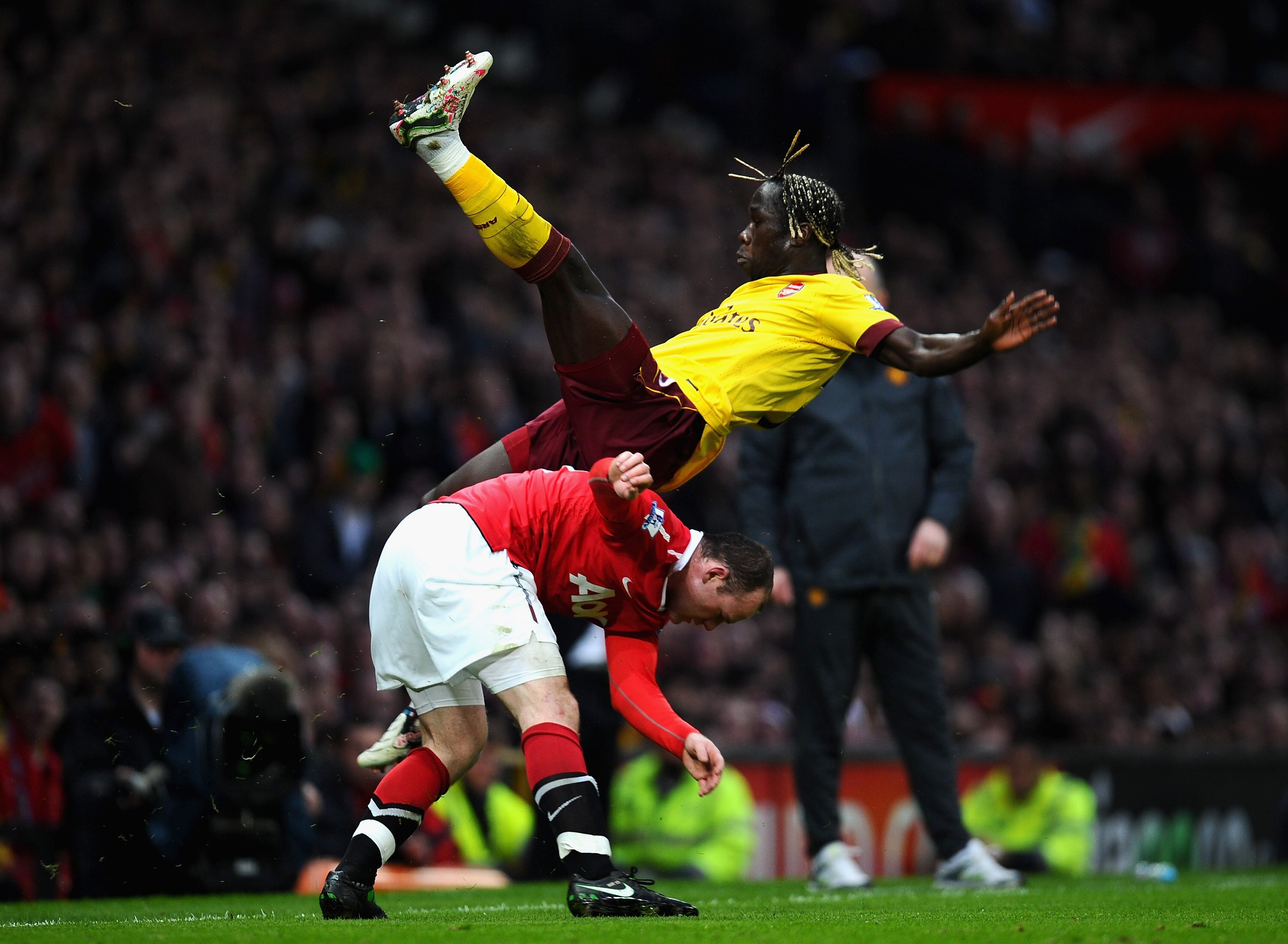 MANCHESTER, ENGLAND - MARCH 12:  Bacary Sagna of Arsenal falls over Wayne Rooney of Manchester United during the FA Cup sponsored by E.On Sixth Round match between Manchester United and Arsenal at Old Trafford on March 12, 2011 in Manchester, England.  (P