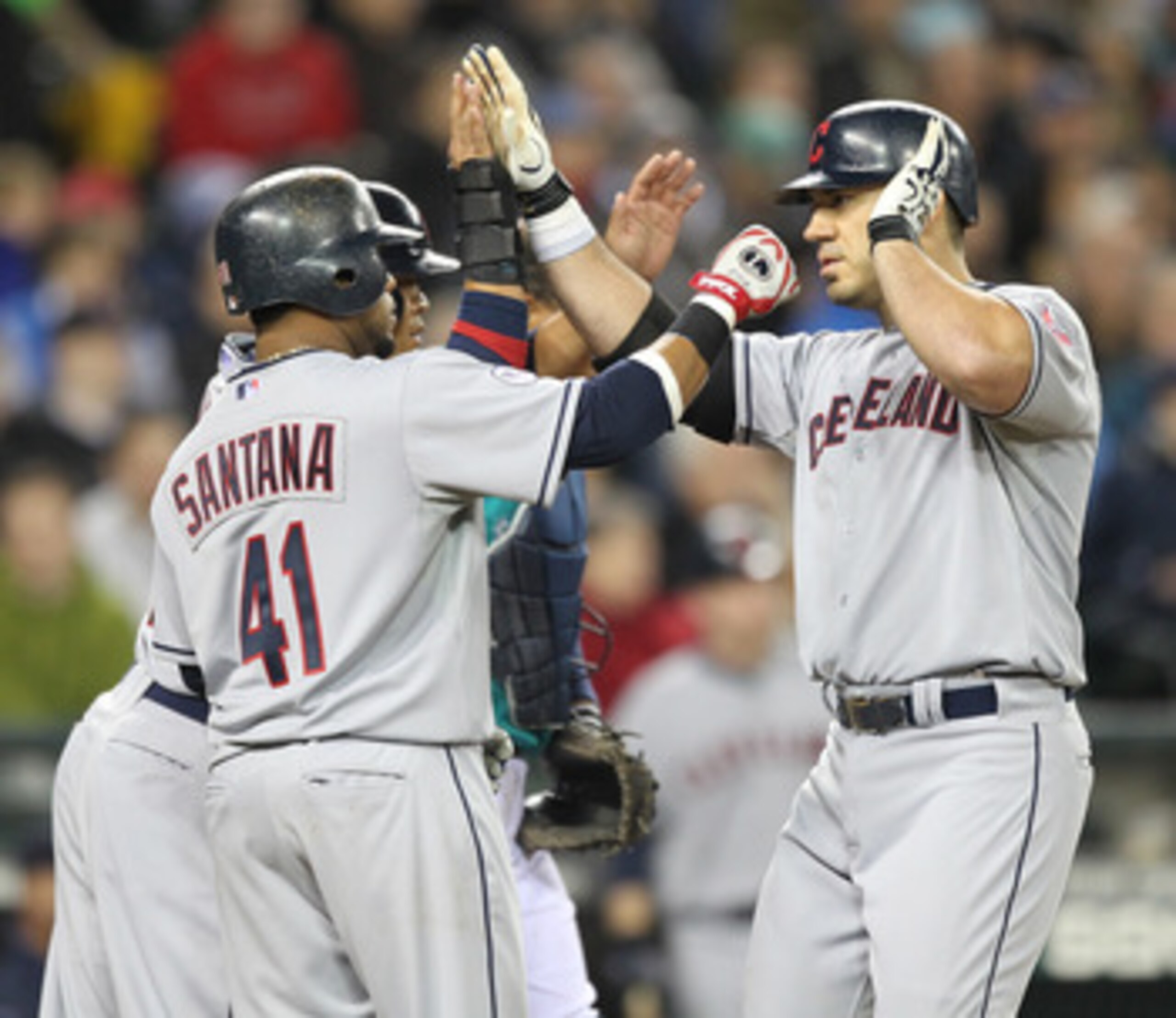 SEATTLE - APRIL 08:  Travis Hafner #48 (R) of the Cleveland Indians is congratulated by Carlos Santana #41 and Shin-Soo Choo #17 after hitting a three run homer against the Seattle Mariners during the Mariners' home opener at Safeco Field on April 8, 2011