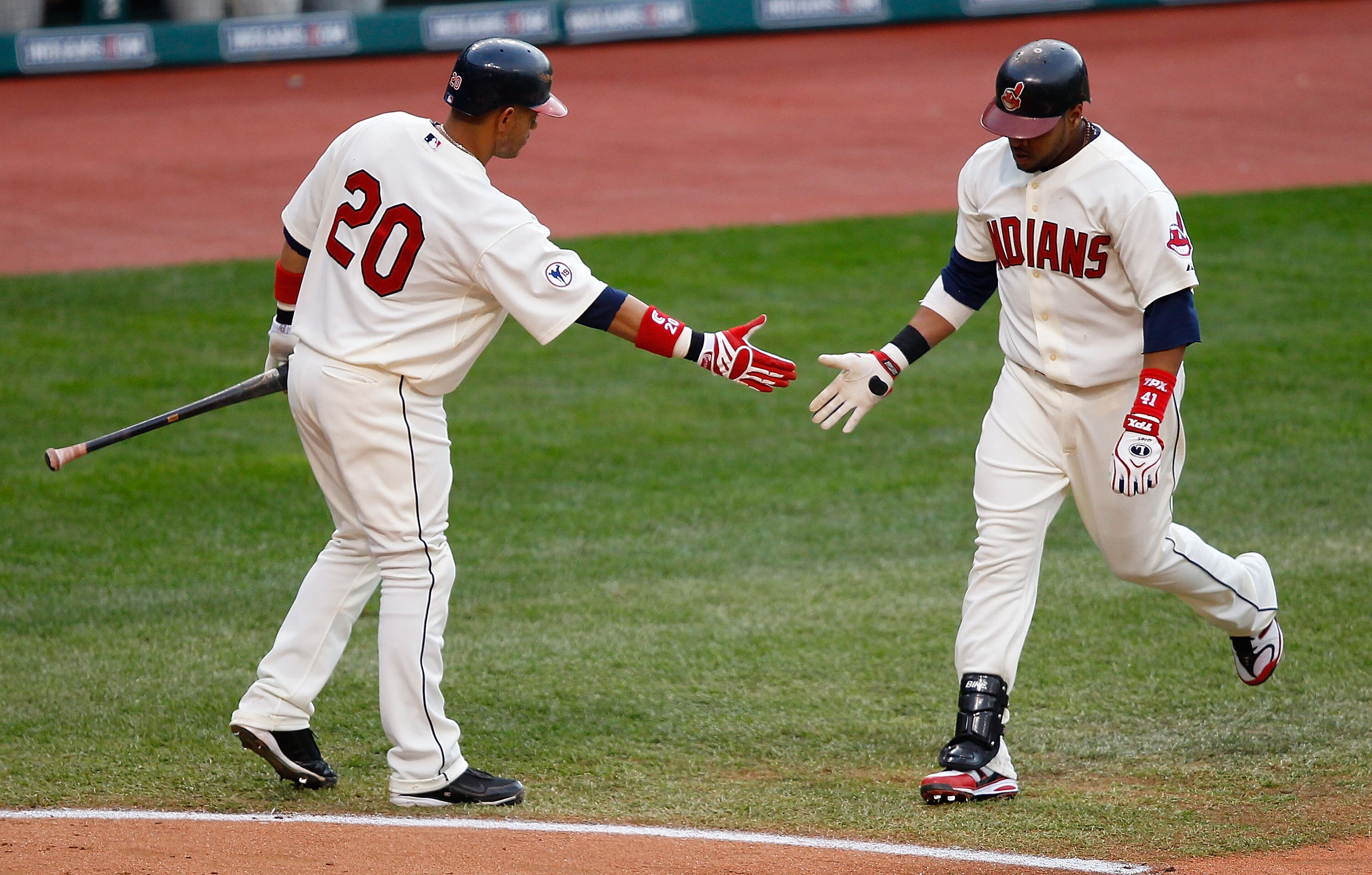 CLEVELAND - APRIL 30:  Carlos Santana #41 of the Cleveland Indians is congratulated by teammate Orlando Cabrera #20 after hitting a home run against the Detroit Tigers during the game on April 30, 2011 at Progressive Field in Cleveland, Ohio.  (Photo by J