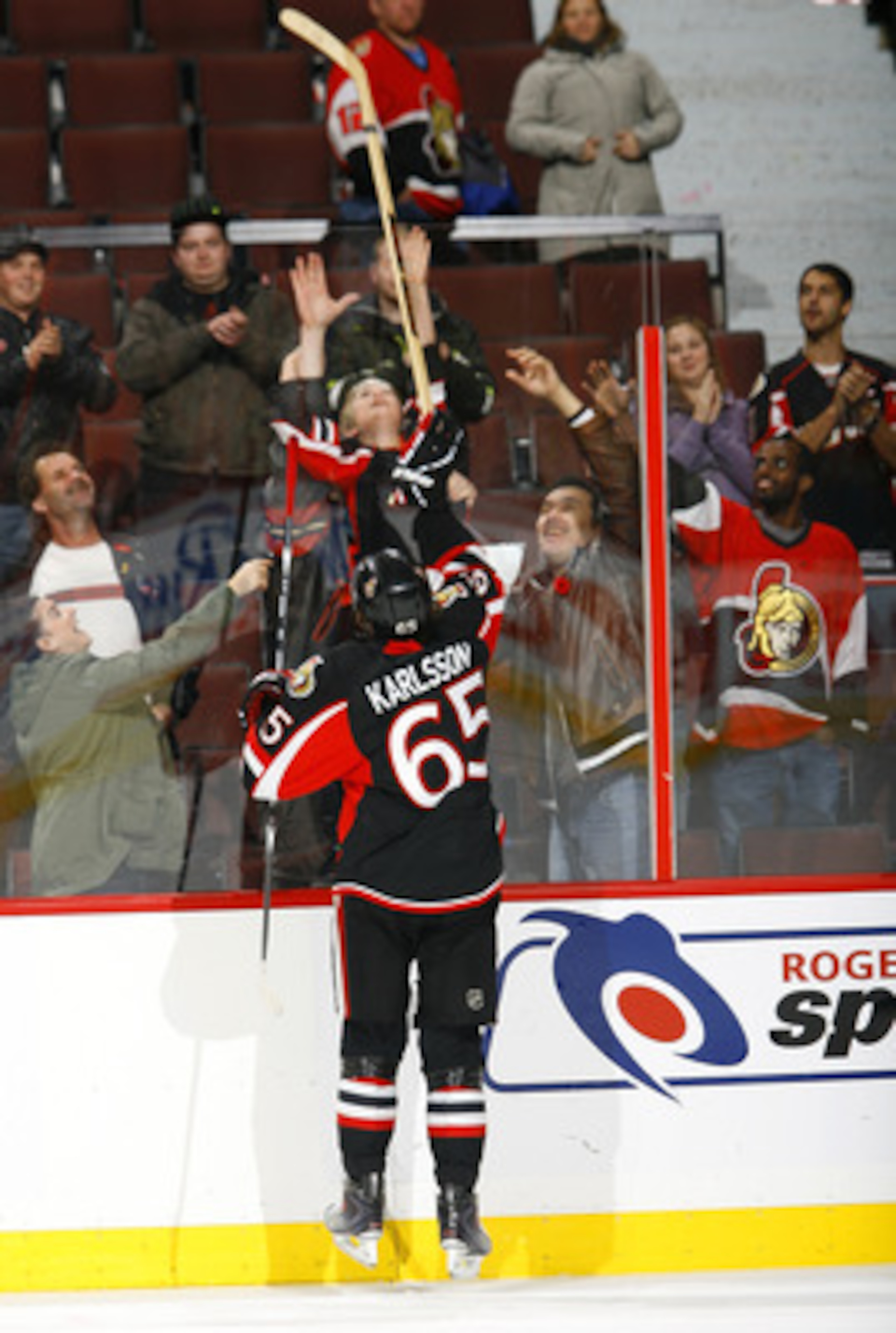 OTTAWA - NOVEMBER 09:  Erik Karlsson #65 of the Ottawa Senators sends his 'Star of the Game' stick over the boards to a young fan at the end of a game against the Atlanta Thrashers at Scotiabank Place on November 9, 2010 in Ottawa, Ontario, Canada.  The O