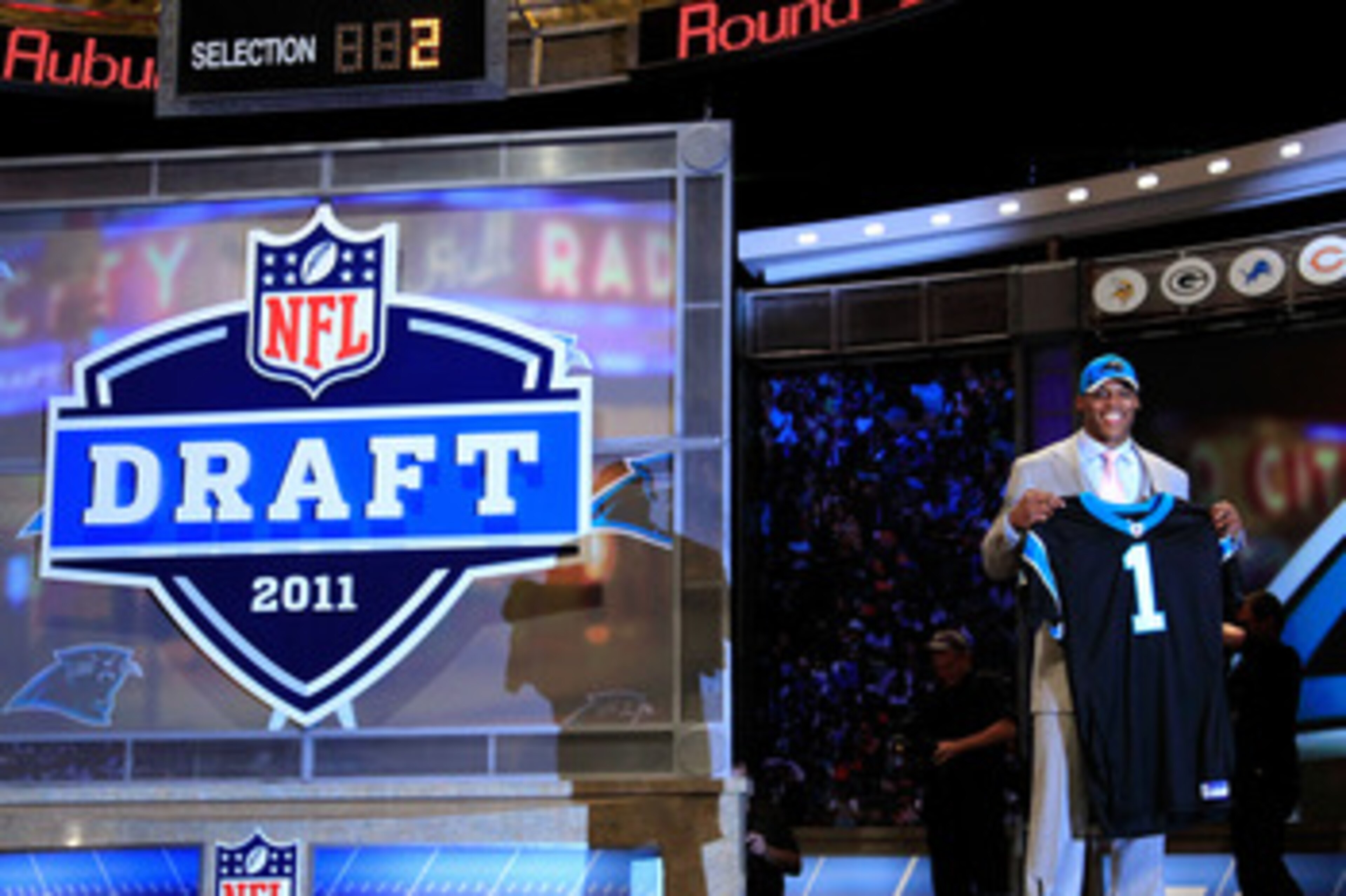 NEW YORK, NY - APRIL 28:  Cam Newton, #1 overall pick by the Carolina Panthers holds up a jersey on stage after he was picked during the 2011 NFL Draft at Radio City Music Hall on April 28, 2011 in New York City.  (Photo by Chris Trotman/Getty Images)