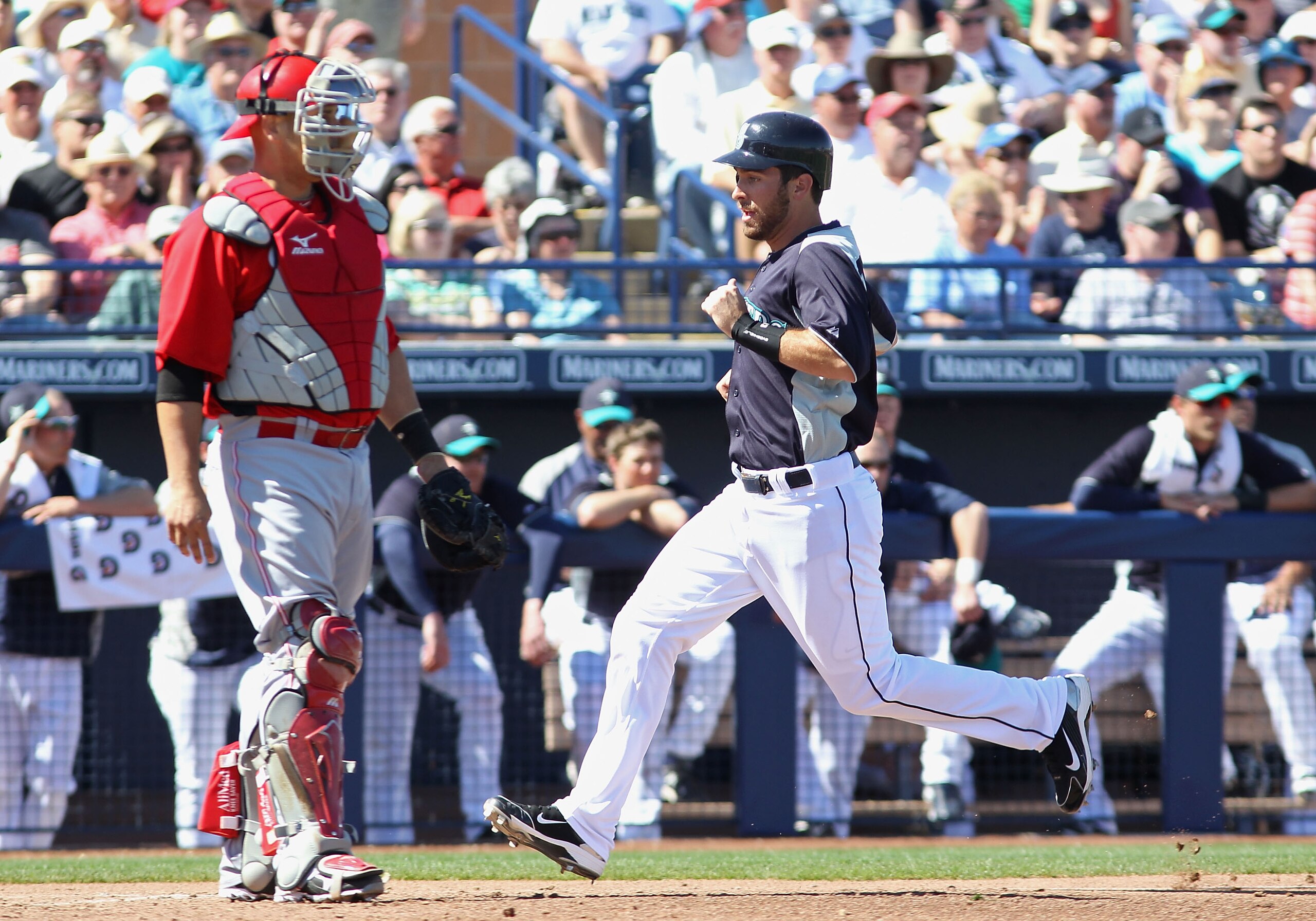 PEORIA, AZ - MARCH 04:  Dustin Ackley #13 of the Seattle Mariners scores a run on a sacrifice fly hit by Ichiro Suzuki (not pictured) during the third inning of the spring training game against the Cincinnati Reds at Peoria Stadium on March 4, 2011 in Peo