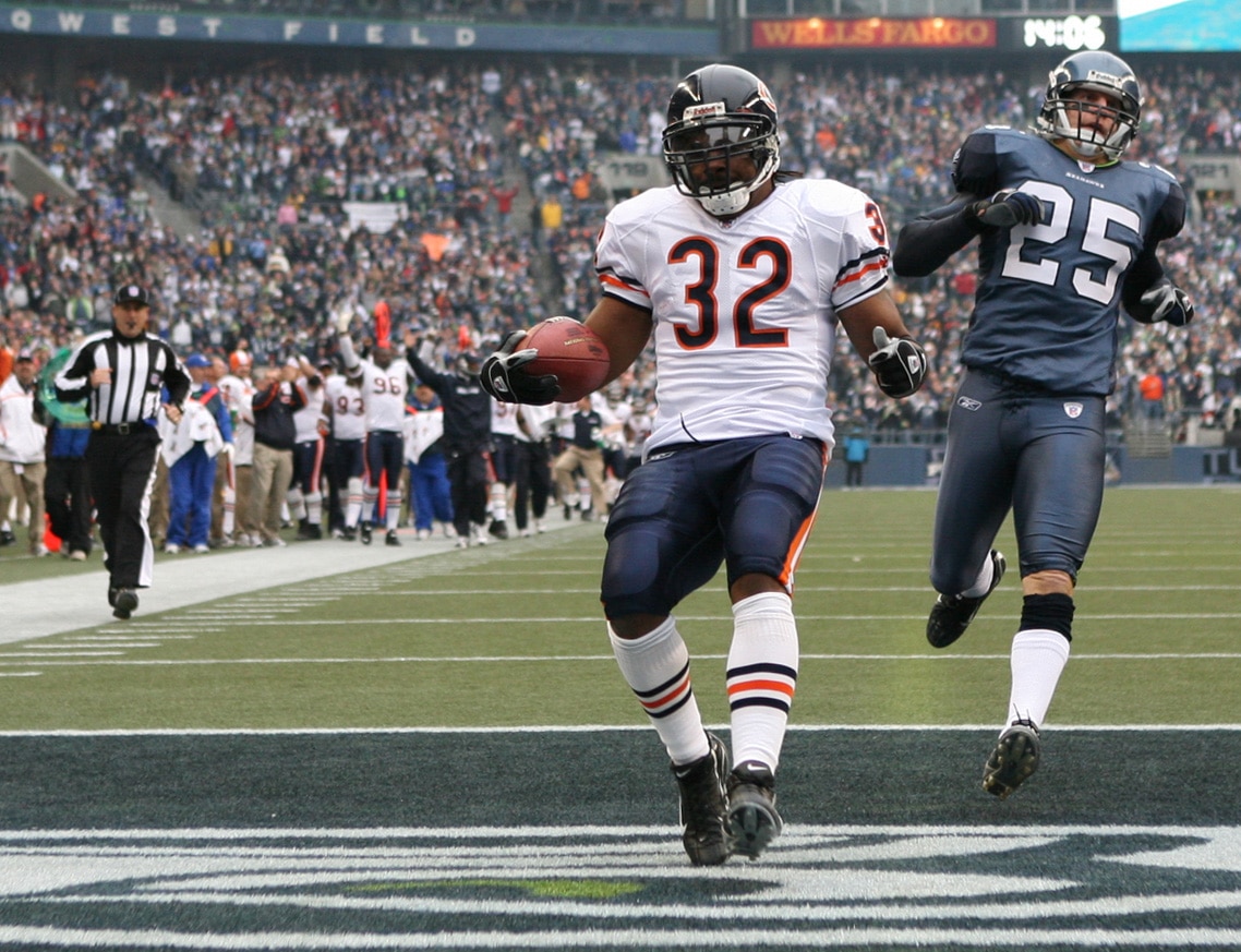 SEATTLE - NOVEMBER 18:  Running back Cedric Benson #32 of the Chicago Bears scores a touchdown in the first quarter against Brian Russell #25 of the Seattle Seahawks at Qwest Field on November 18, 2007 in Seattle, Washington. The Seahawks defeated the Bea