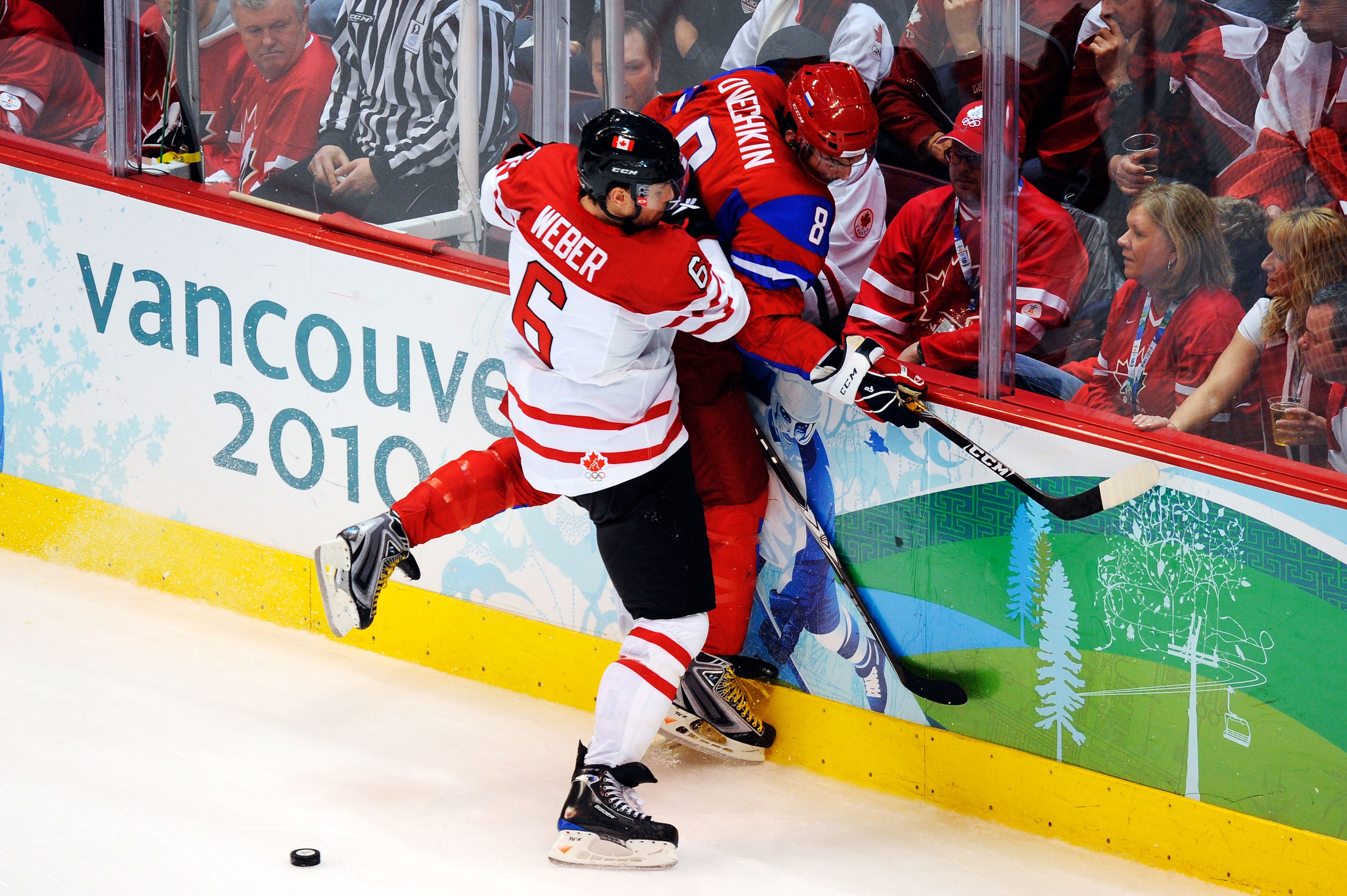 VANCOUVER, BC - FEBRUARY 24:  Shea Weber #6 of Canada checks Alexander Ovechkin #8 of Russia into the boards during the ice hockey men's quarter final game between Russia and Canada on day 13 of the Vancouver 2010 Winter Olympics at Canada Hockey Place on