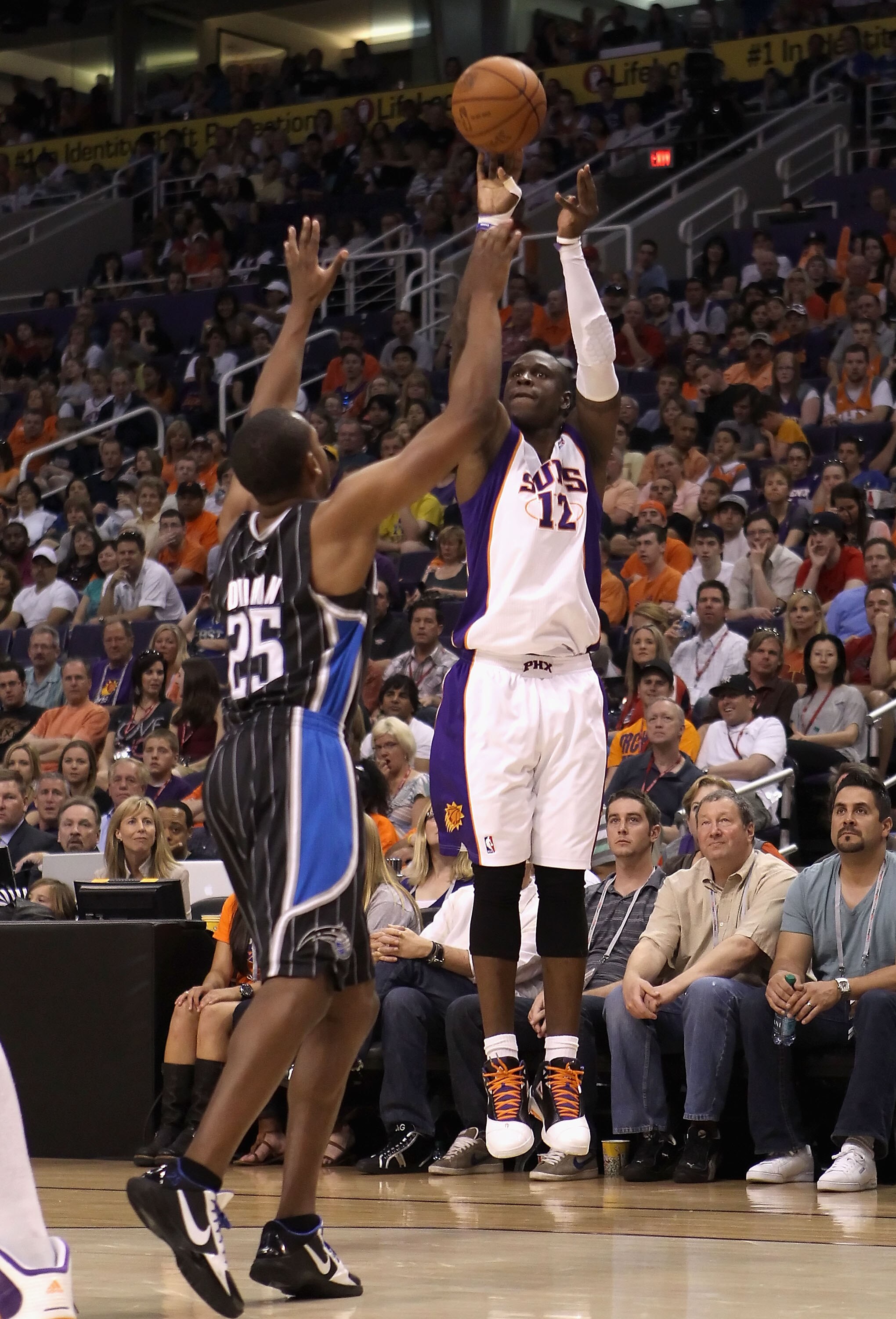 PHOENIX, AZ - MARCH 13:  Mickael Pietrus #12 of the Phoenix Suns attempts a three point shot over Chris Duhon #25 of the Orlando Magic during the NBA game at US Airways Center on March 13, 2011 in Phoenix, Arizona. The Magic defeated the Suns 111-88. NOTE