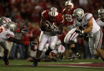 MADISON, WI - OCTOBER 16: John Clay #32 of the Wisconsin Badgers runs between Orhian Johnson #19 and Nathan Williams #43 of the Ohio State Buckeyes at Camp Randall Stadium on October 16, 2010 in Madison, Wisconsin. Wisconsin defeated Ohio State 31-18. (Ph