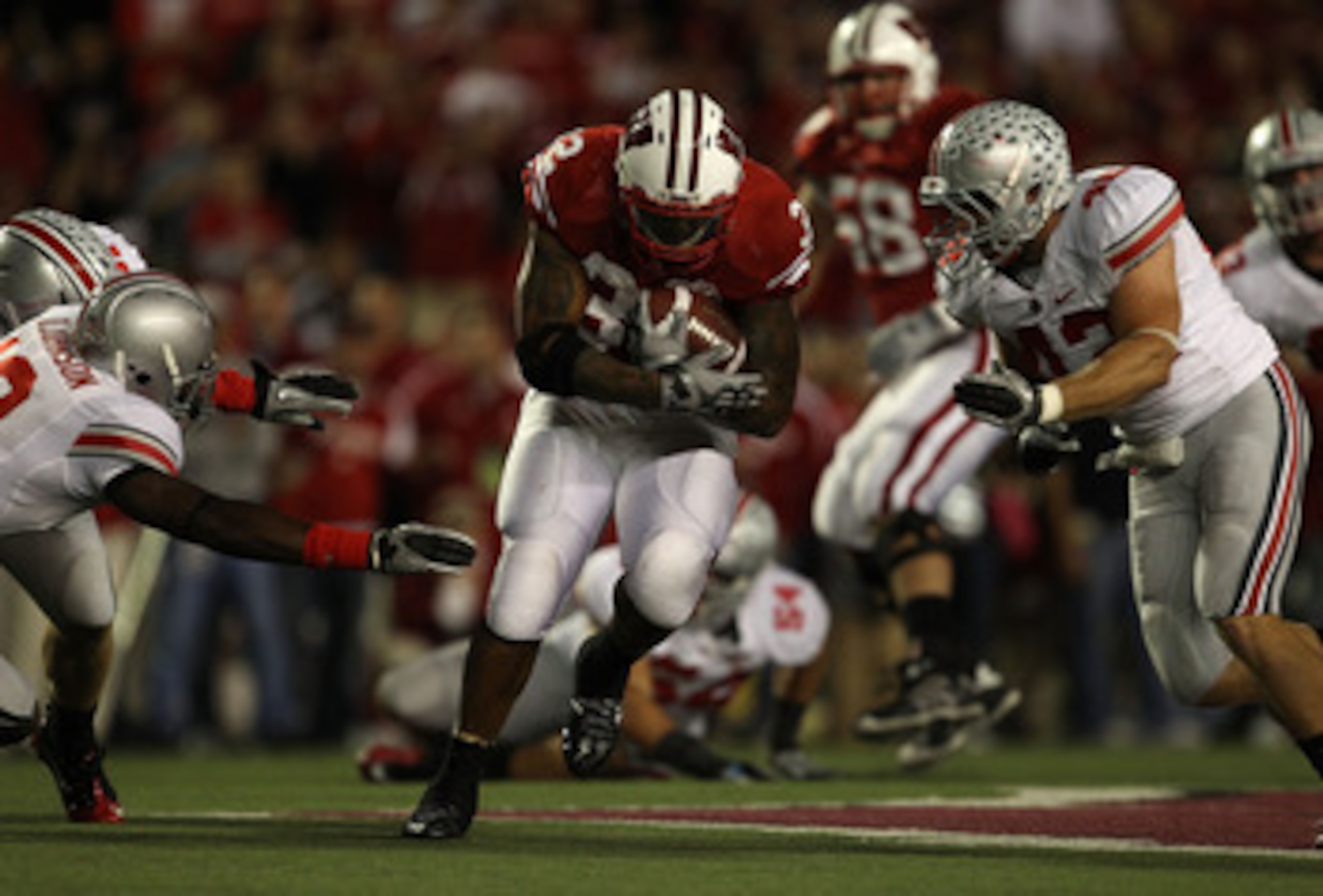 MADISON, WI - OCTOBER 16: John Clay #32 of the Wisconsin Badgers runs between Orhian Johnson #19 and Nathan Williams #43 of the Ohio State Buckeyes at Camp Randall Stadium on October 16, 2010 in Madison, Wisconsin. Wisconsin defeated Ohio State 31-18. (Ph