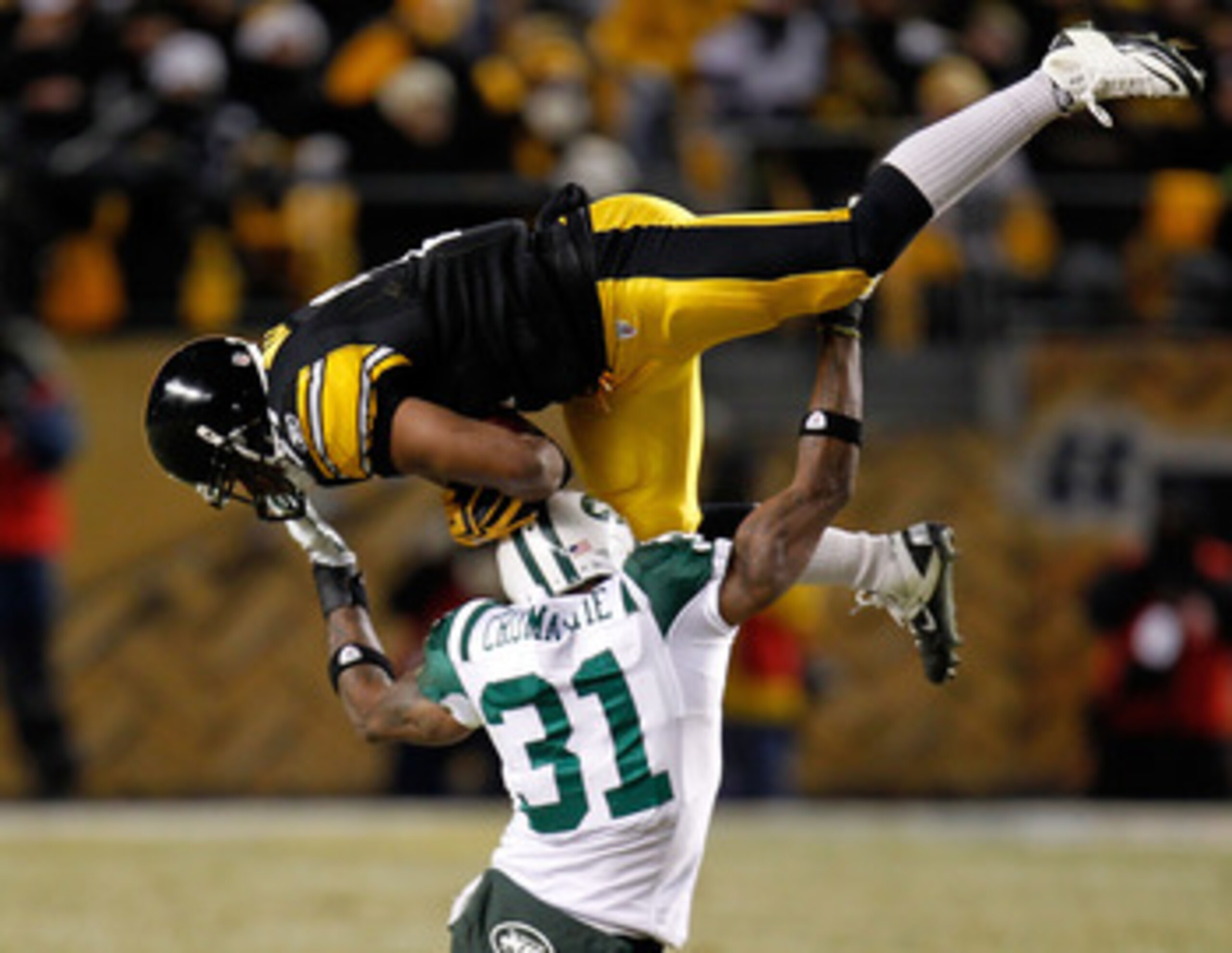 PITTSBURGH, PA - JANUARY 23:  Mewelde Moore #21 of the Pittsburgh Steelers catches a pass over Antonio Cromartie #31 of the New York Jets in the third quarter of the 2011 AFC Championship game at Heinz Field on January 23, 2011 in Pittsburgh, Pennsylvania