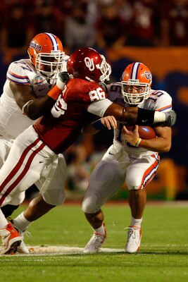 MIAMI - JANUARY 08:  Tim Tebow #15 of the Florida Gators is tackled by Adrian Taylor #86 of the Oklahoma Sooners as Tebow runs for a first down on a 3rd down and 1 in the first quarter during the FedEx BCS National Championship game at Dolphin Stadium on