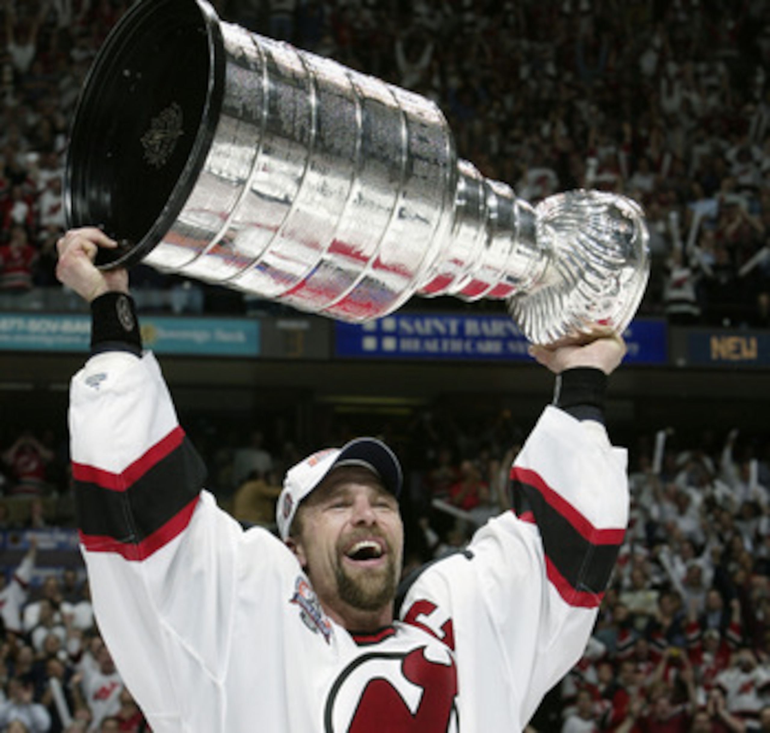 EAST RUTHERFORD, NJ - JUNE 9:  Scott Stevens #4 of the New Jersey Devils holds up the Stanley Cup after defeating the Mighty Ducks of Anaheim 3-0 in game seven of the 2003 Stanley Cup Finals at Continental Airlines Arena on June 9, 2003 in East Rutherford