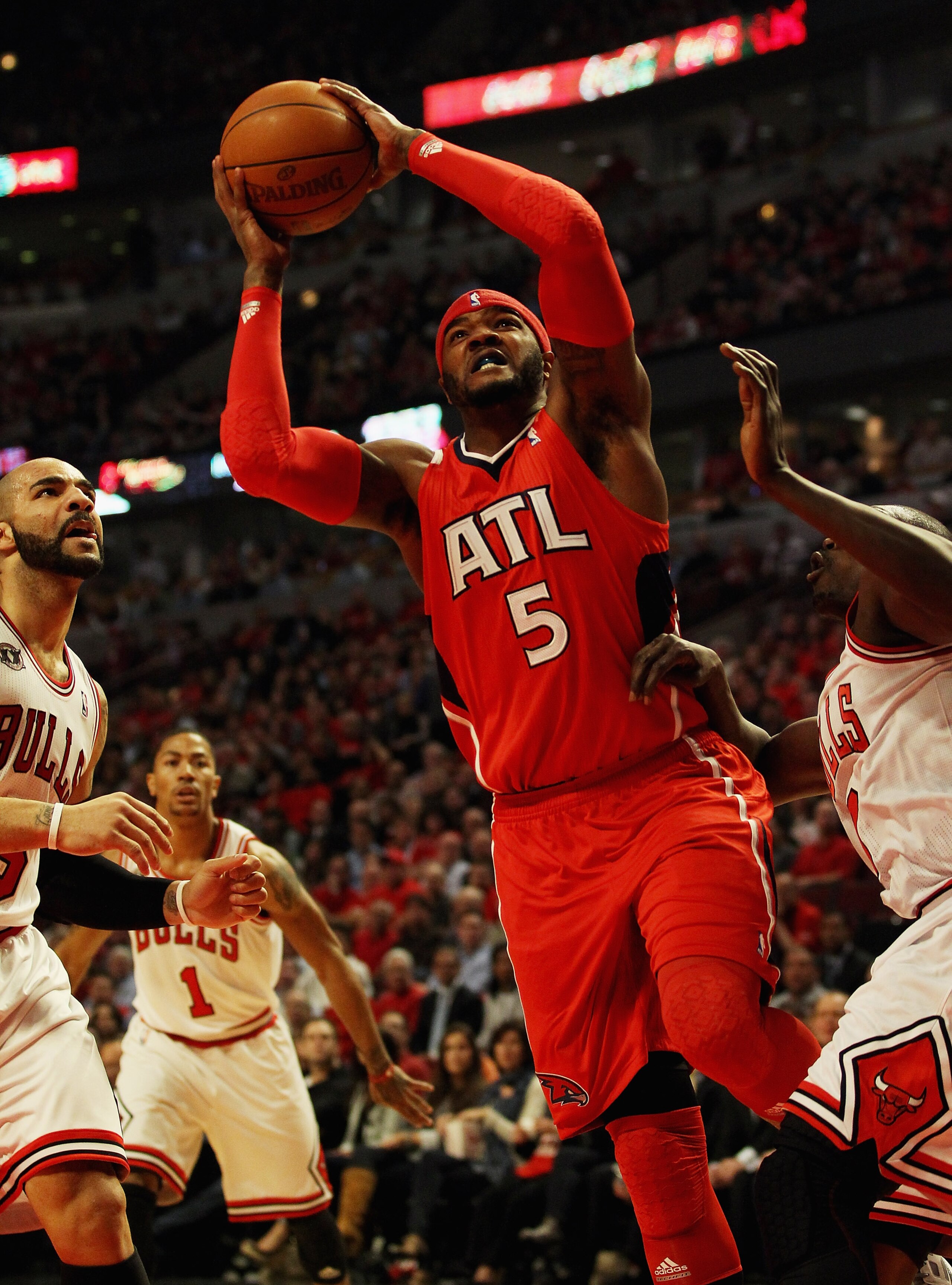 CHICAGO, IL - MAY 02: Josh Smith #5 of the Atlanta Hawks drives between Carlos Boozer #5 and Loul Deng #9 of the Chicago Bulls in Game One of the Eastern Conference Semifinals in the 2011 NBA Playoffs at the United Center on May 2, 2011 in Chicago, Illino