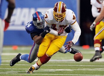 EAST RUTHERFORD, NJ - DECEMBER 05:  Deon Grant #34 of the New York Giants forces a fourth quarter fumble against Chris Cooley #47 of the Washington Redskins on December 5, 2010 at the New Meadowlands Stadium in East Rutherford, New Jersey. The Giants defe