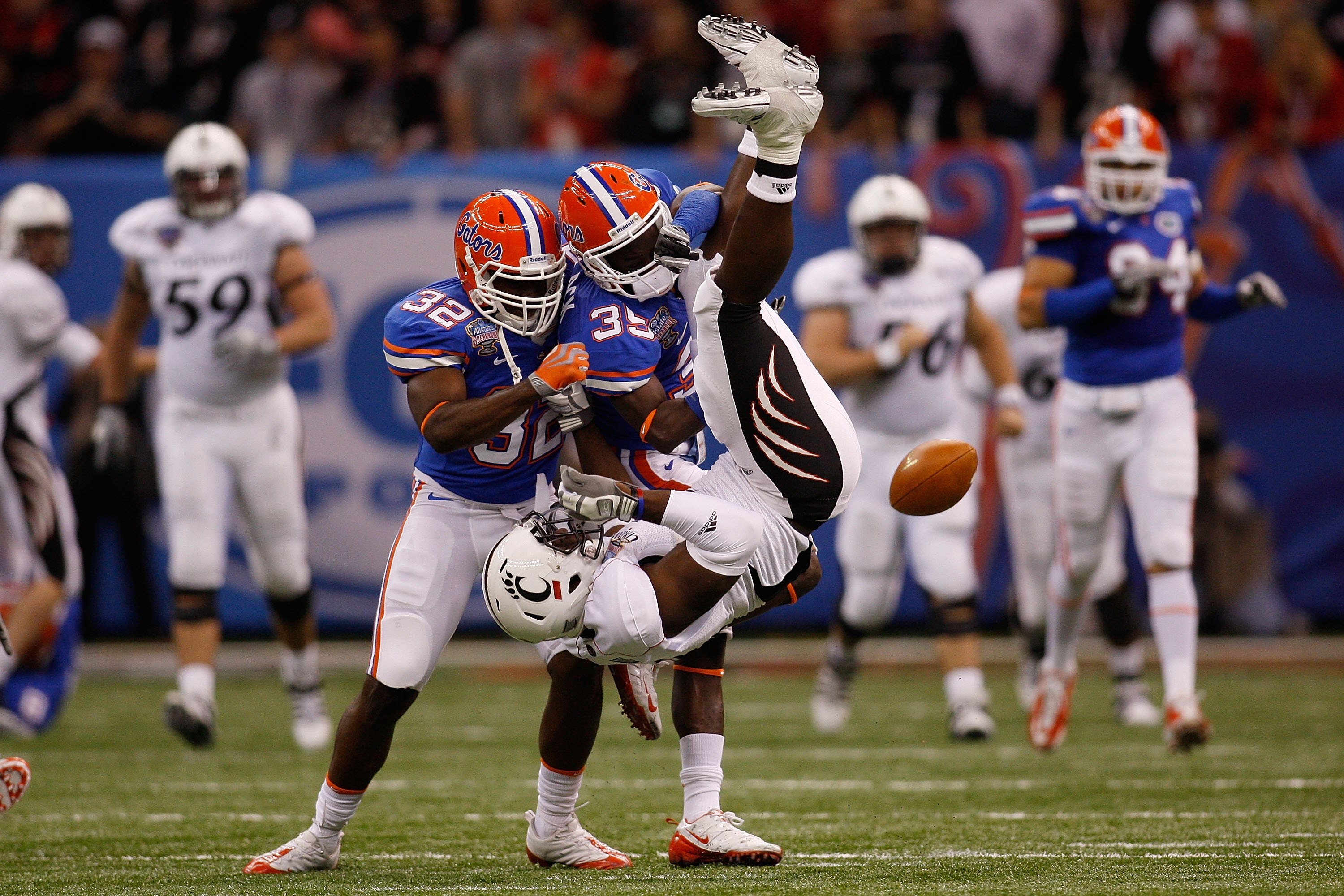 NEW ORLEANS - JANUARY 01: Deonte Thompson #8 of the Cincinnati Bearcats is flipped upside down by Ahmad Black #35 and Dustin Doe #32 of the Florida Gators during the Allstate Sugar Bowl at the Louisana Superdome on January 1, 2010 in New Orleans, Louisian
