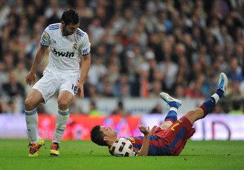 MADRID, SPAIN - APRIL 16:  David Villa (R) of Barcelona lays on the pitch after being fouled by  Raul Albiol (L) of Real Madrid during the la Liga match between Real Madrid and Barcelona at Estadio Santiago Bernabeu on April 16, 2011 in Madrid, Spain.  (P
