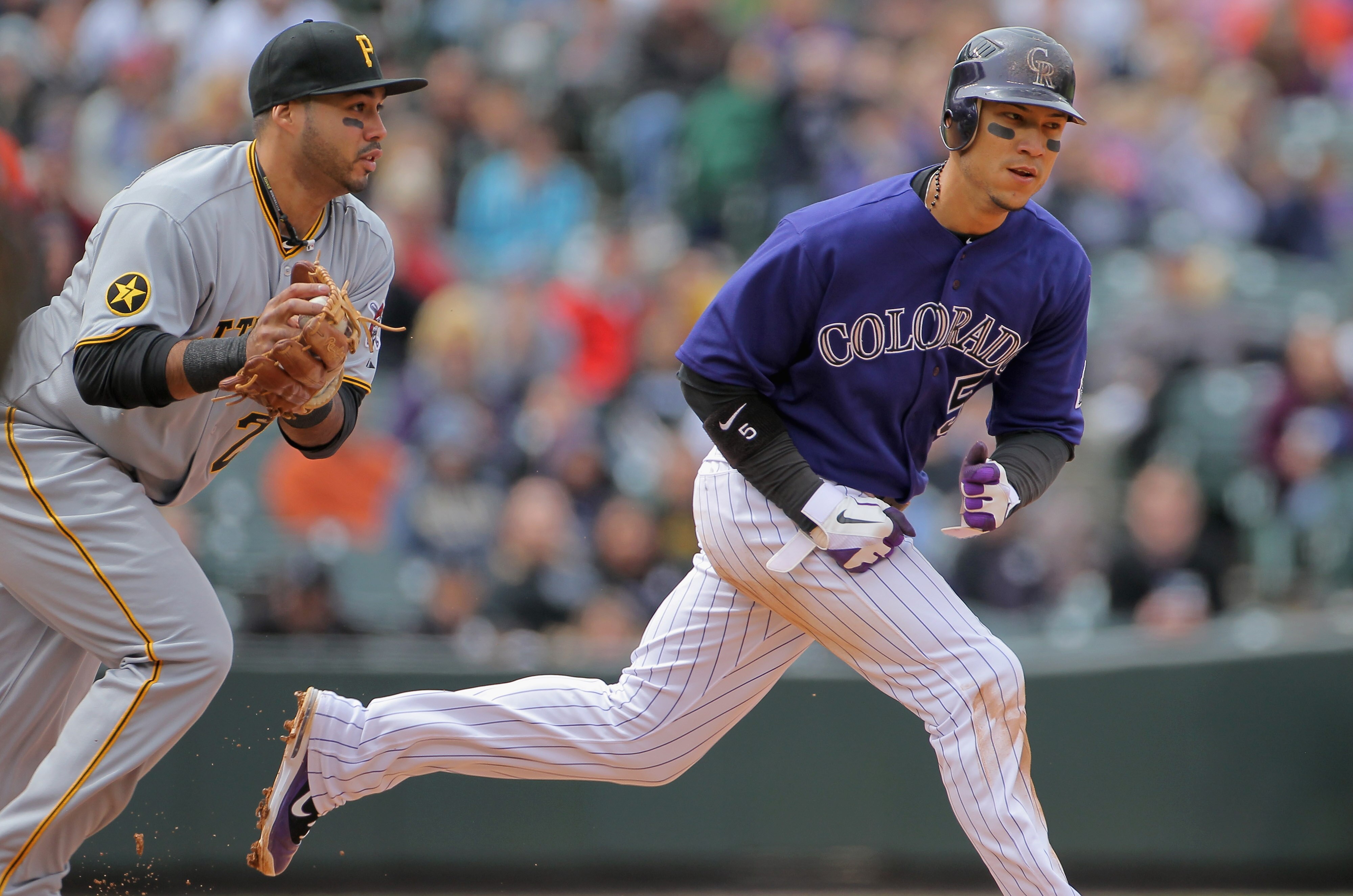 DENVER, CO - MAY 01:  Carlos Gonzalez #5 of the Colorado Rockies is caught in a rundown by third baseman Pedro Alvarez #24 of the Pittsburgh Pirates at Coors Field on May 1, 2011 in Denver, Colorado. The Pirates defeated the Rockies 8-4.  (Photo by Doug P