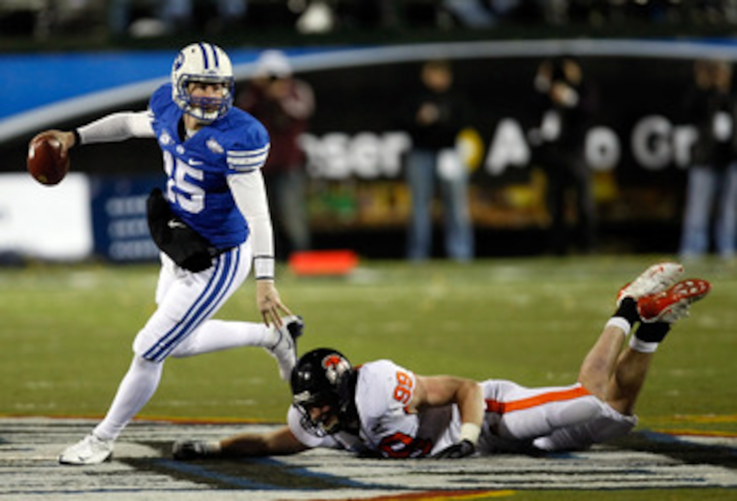 LAS VEGAS - DECEMBER 22:  Quarterback Max Hall #15 of the Brigham Young University Cougars gets away from Gabe Miller #99 of the Oregon State Beavers during the MAACO Las Vegas Bowl at Sam Boyd Stadium December 22, 2009 in Las Vegas, Nevada.  (Photo by Et