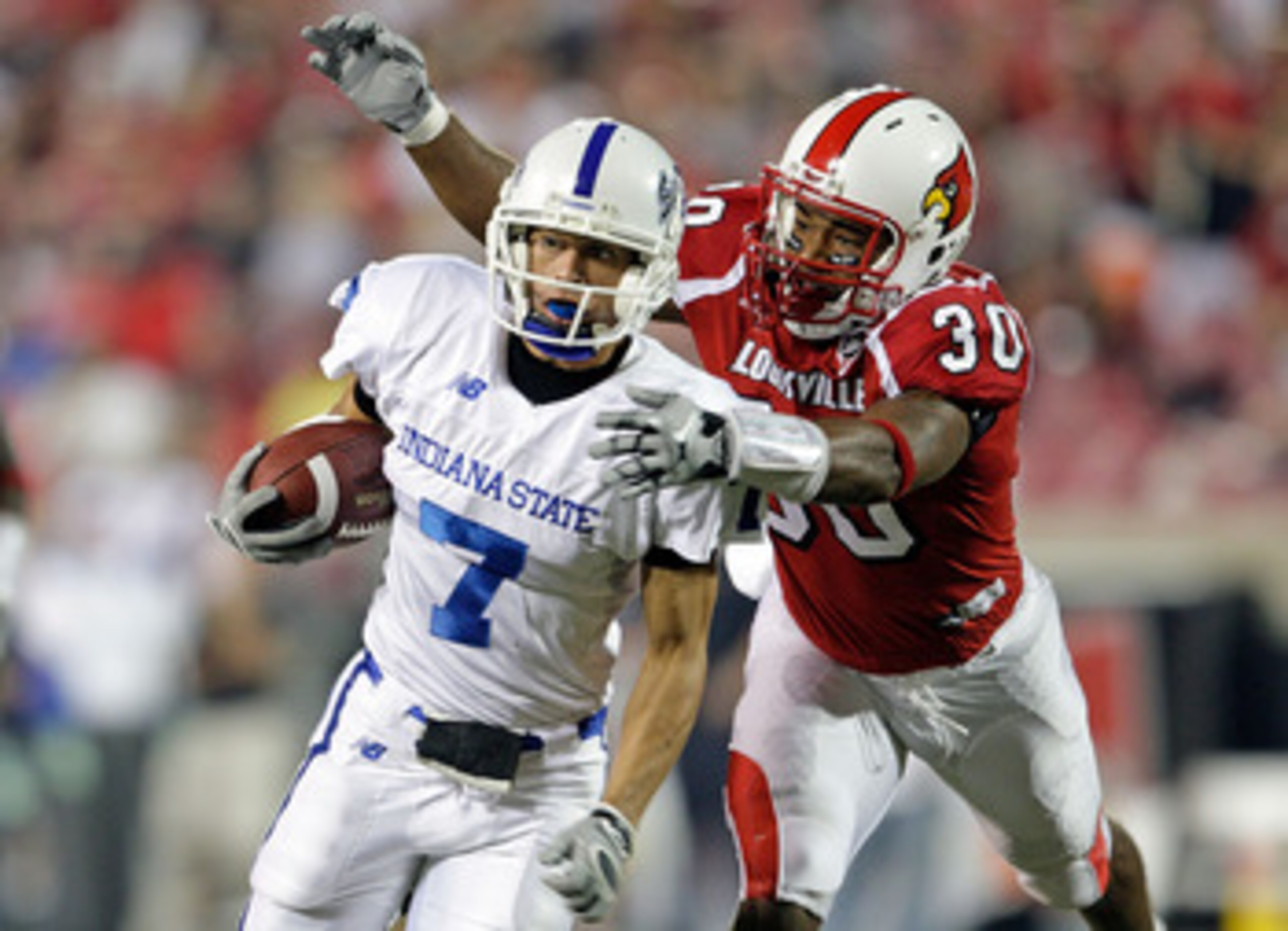 LOUISVILLE, KY - SEPTEMBER 05:  Daniel Covington #30 of the Louisville Cardinals tackles Larry Lacotti #7 of the Indiana State Sycamores during the game at Papa John's Cardinal Stadium on September 5, 2009 in Louisville, Kentucky.  (Photo by Andy Lyons/Ge