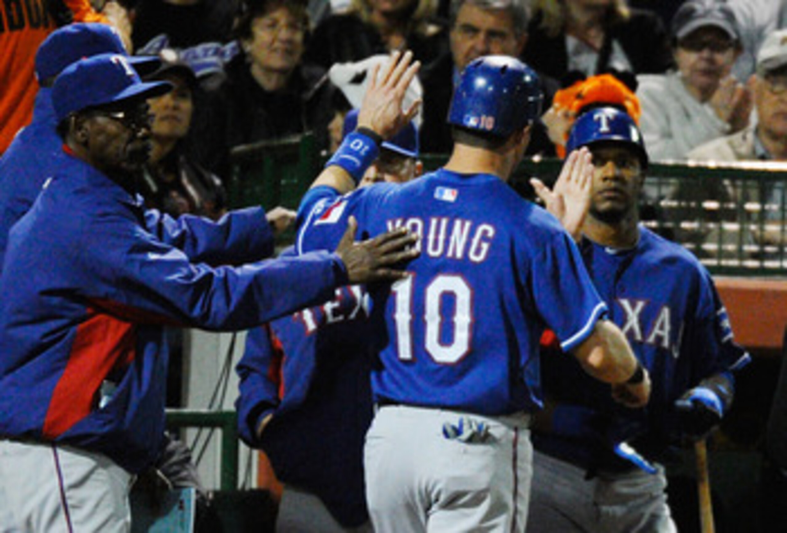 SCOTTSDALE, AZ - MARCH 07:  Michael Young #10 of the Texas Rangers is congratulated by manager Ron Washington (L) after scoring a run on a double by teammate Yorvit Torrealba in the first inning against the San Francisco Giants in the first meeting betwee