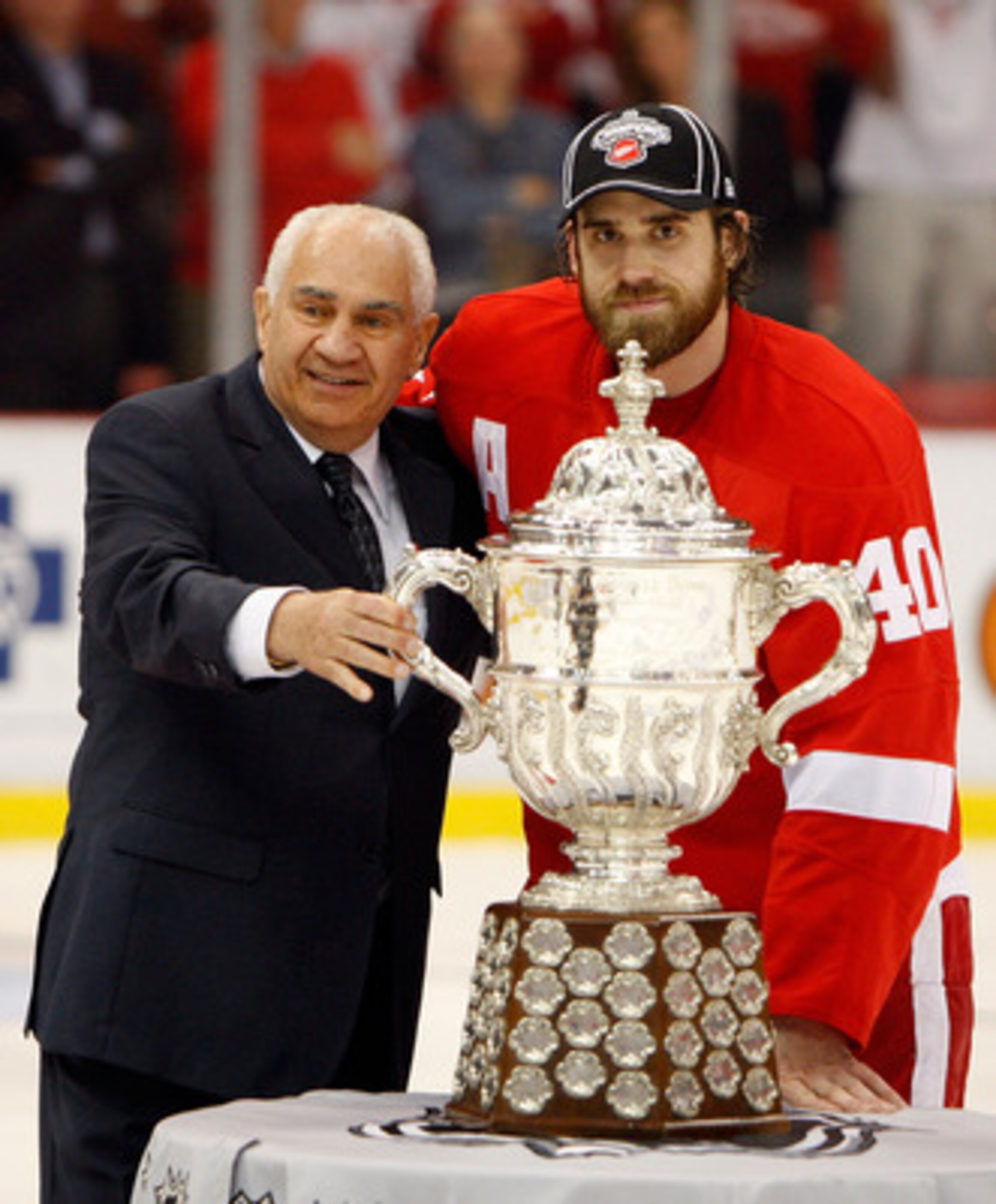 DETROIT - MAY 27:  Henrik Zetterberg #40 (R) of the Detroit Red Wings recieves the Clarence S. Campbell Bowl from NHL Senior Vice President of Hockey Operations Jim Gregory after the Red Wings won 2-1 in overtime against the Chicago Blackhawks during Game