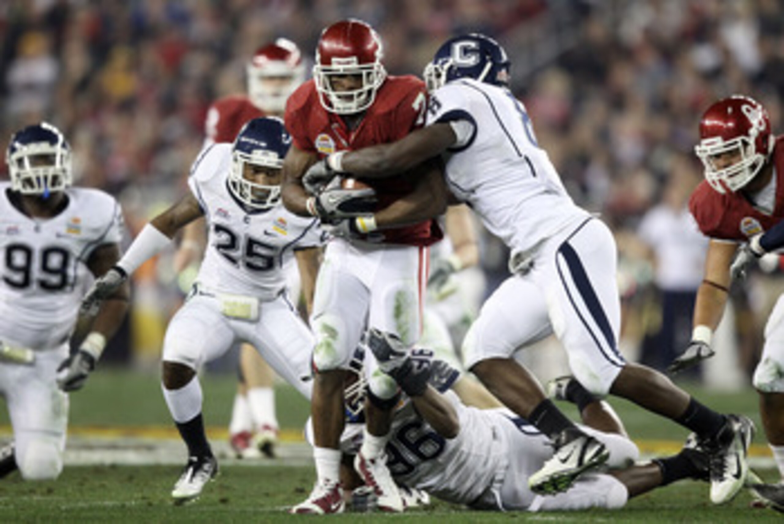 GLENDALE, AZ - JANUARY 01:  DeMarco Murray #7 of the Oklahoma Sooners runs the ball as he is hit bu Lawrence Wilson #8 of the Connecticut Huskies in the second quarter during the Tostitos Fiesta Bowl at the Universtity of Phoenix Stadium on January 1, 201