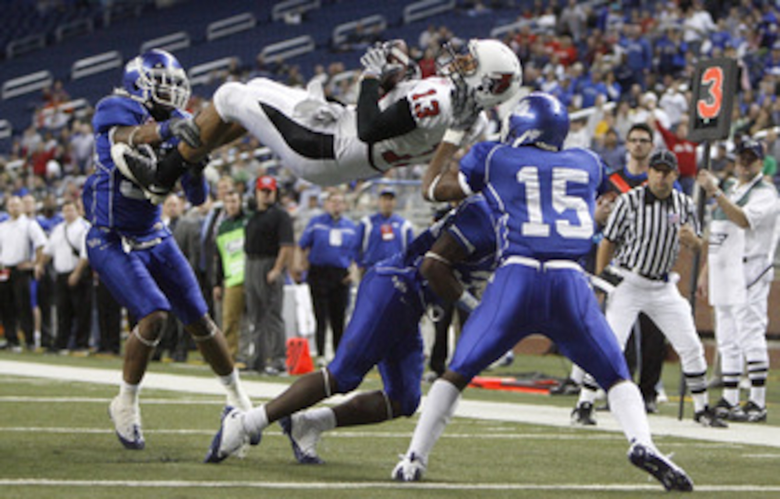 DETROIT - DECEMBER 05: Nate Davis #13 of the Ball State Cardinals is hit on the goal line by Josh Thomas #15, Mike Newton #30 and Justin Winters #34 of the Buffalo Bulls in the MAC Championship game on December 5, 2008 at Ford Field in Detroit, Michigan. 