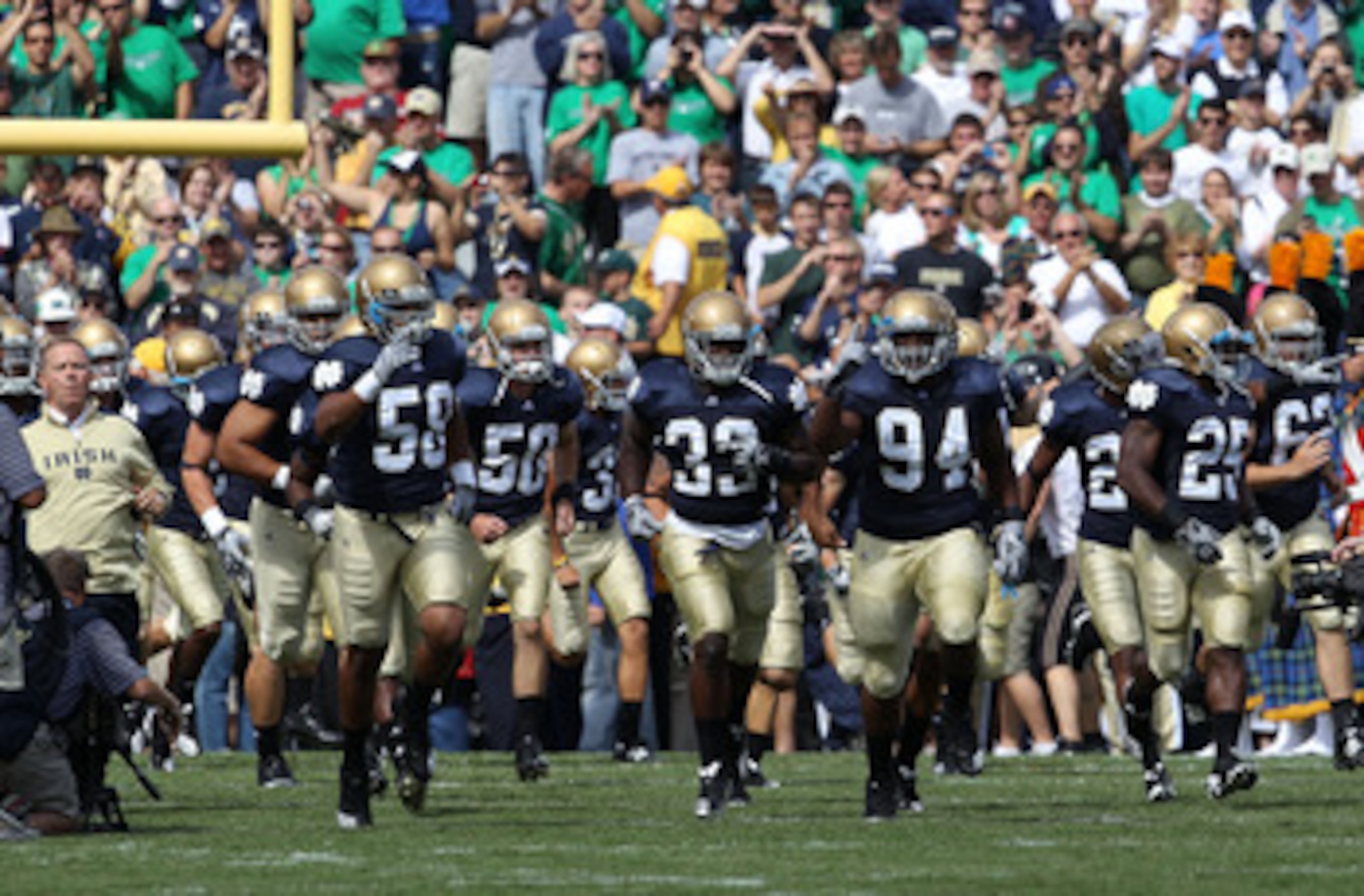 SOUTH BEND, IN - SEPTEMBER 04: Members of the Notre Dame Fighting Irish, along with coach Brian Kelly (L), run onto the field before a game against the Purdue Boilermakers at Notre Dame Stadium on September 4, 2010 in South Bend, Indiana. Notre Dame defea SOUTH BEND, IN - SEPTEMBER 04: Members of the Notre Dame Fighting Irish, along with coach Brian Kelly (L), run onto the field before a game against the Purdue Boilermakers at Notre Dame Stadium on September 4, 2010 in South Bend, Indiana. Notre Dame defea