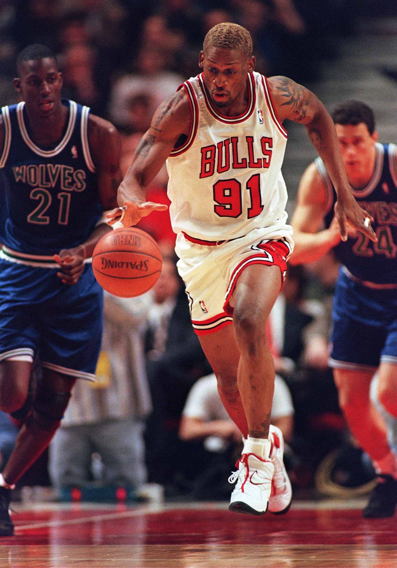 27 Feb 1996: Forward Dennis Rodman #91 of the Chicago Bulls breaks down the court after picking up an offensive rebound as Kevin Garnett #21 of the Minnesota Timberwolves looks on during the game at the United Center in Chicago, Illinois.