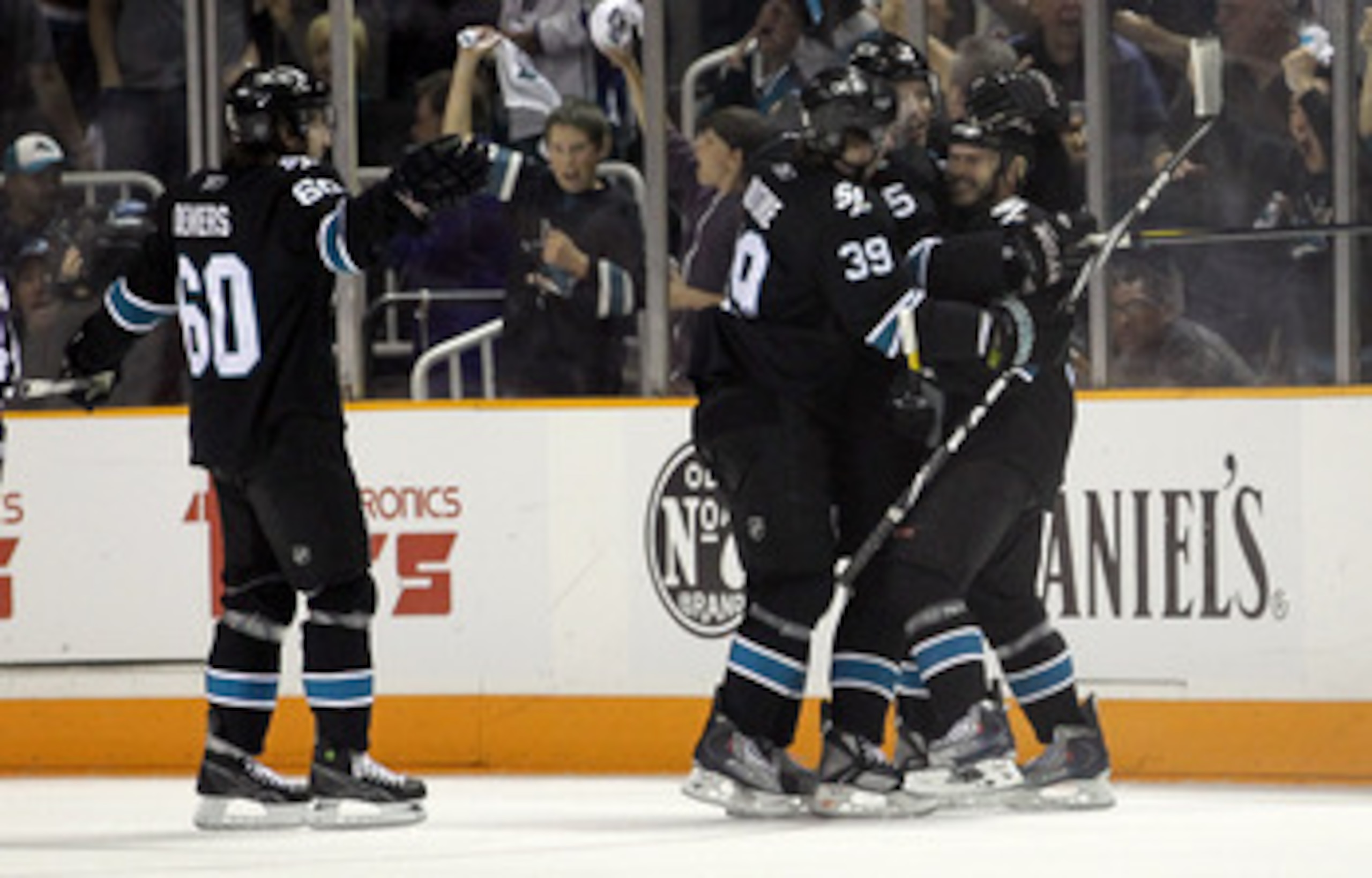 SAN JOSE, CA - MAY 01:  Ian White #9 is congratulated by Dany Heatley #15,Logan Couture #39, and Jason Demers #60 of the San Jose Sharks after he scored a goal in the first period against the Detroit Red Wings in Game Two of the Western Conference Semifin