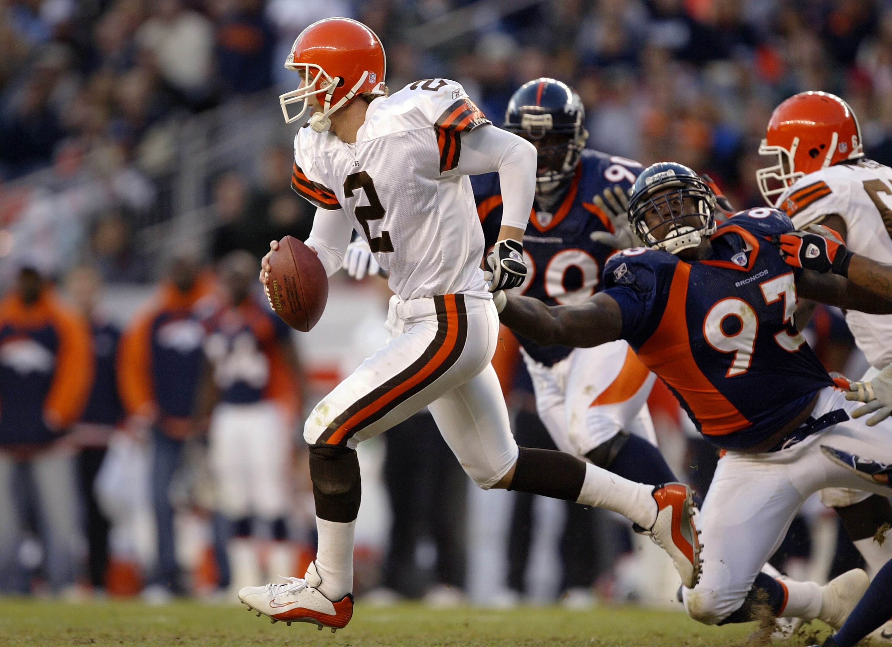 DENVER - DECEMBER 14:  Quarterback Tim Couch #2 of the Cleveland Browns runs out of the pocket on a flea flicker against defensive end Trevor Pryce #93 of the Denver Broncos December 14, 2003 at Invesco Field at Mile High in Denver, Colorado. The Broncos 