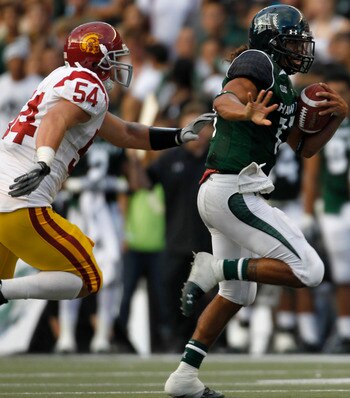 HONOLULU - SEPTEMBER 02: Quarterback Bryant Moniz #17 of the University of Hawaii Warriors is chased by Chris Galippo #54 of the University of Southern California Trojans as he carries the ball during first half action against the University of Southern C