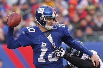 EAST RUTHERFORD, NJ - DECEMBER 19:  Eli Manning #10 of the New York Giants is sacked by Moise Fokou #53 of the Philadelphia Eagles at New Meadowlands Stadium on December 19, 2010 in East Rutherford, New Jersey.  (Photo by Nick Laham/Getty Images)