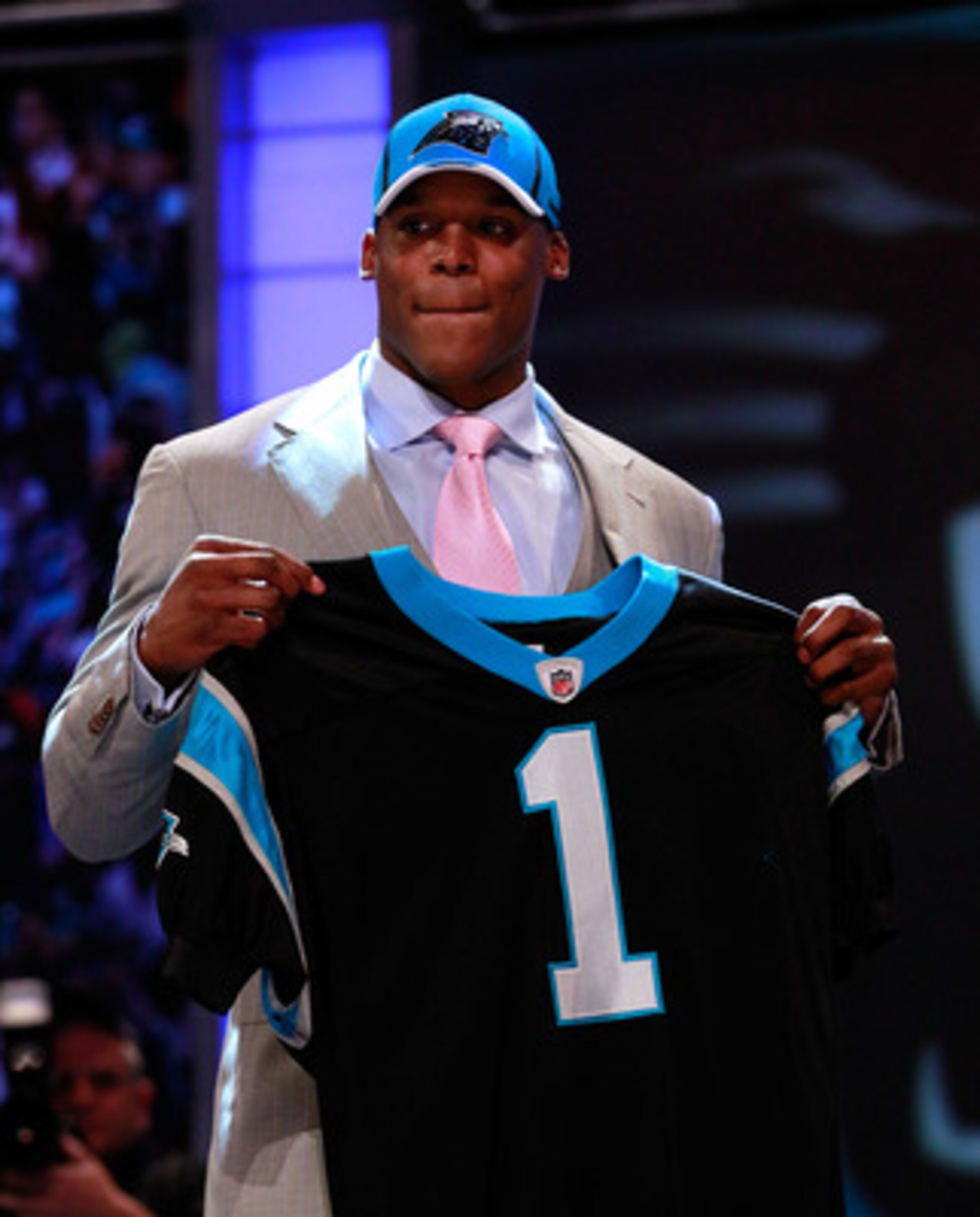 NEW YORK, NY - APRIL 28:  Cam Newton, #1 overall pick by the Carolina Panthers holds up a jersey on stage after he was picked during the 2011 NFL Draft at Radio City Music Hall on April 28, 2011 in New York City.  (Photo by Chris Trotman/Getty Images)