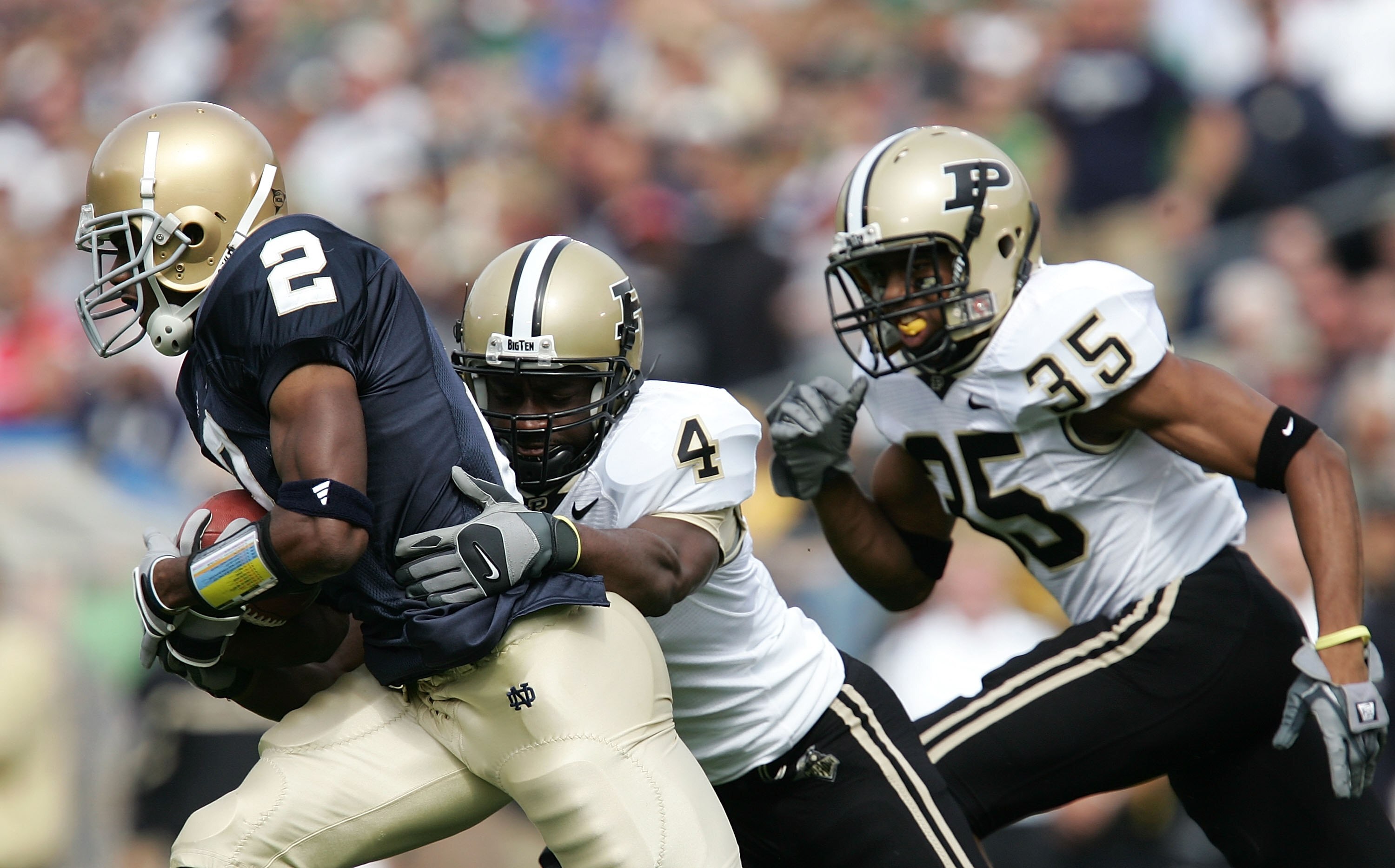 SOUTH BEND, IN - SEPTEMBER 30:  Darrin Walls #2 of the Notre Dame Fighting Irish runs with the ball against Fabian Martin #4 and David Pender #35 of the Purdue Boilermakers September 30, 2006 at Notre Dame Stadium in South Bend, Indiana. Notre Dame won 35