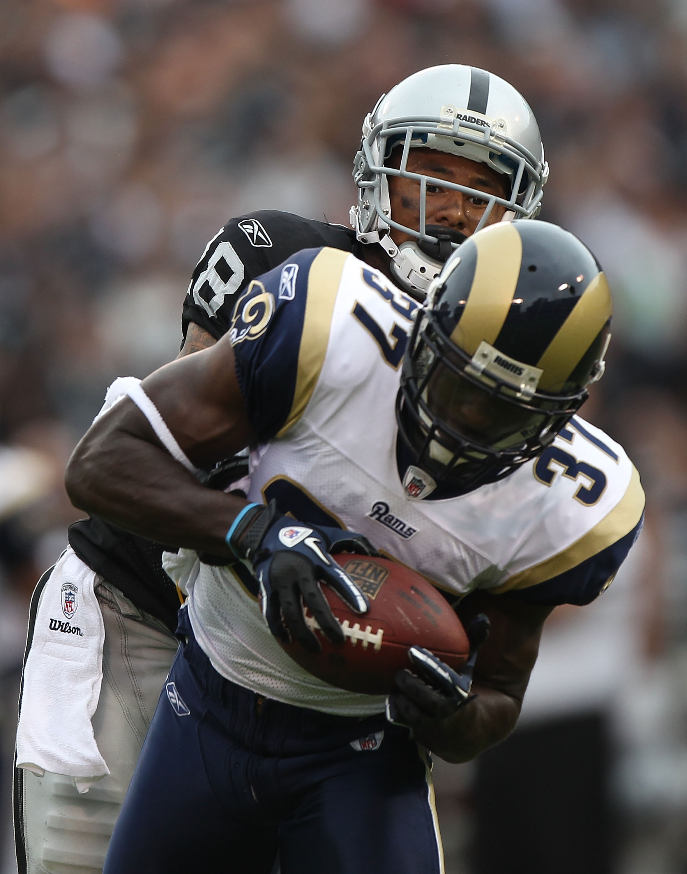 OAKLAND, CA - SEPTEMBER 19:  James Butler #37 of the St. Louis Rams intercepts the ball past Louis Murphy #18 of the Oakland Raiders during an NFL game at Oakland-Alameda County Coliseum on September 19, 2010 in Oakland, California.  (Photo by Jed Jacobso