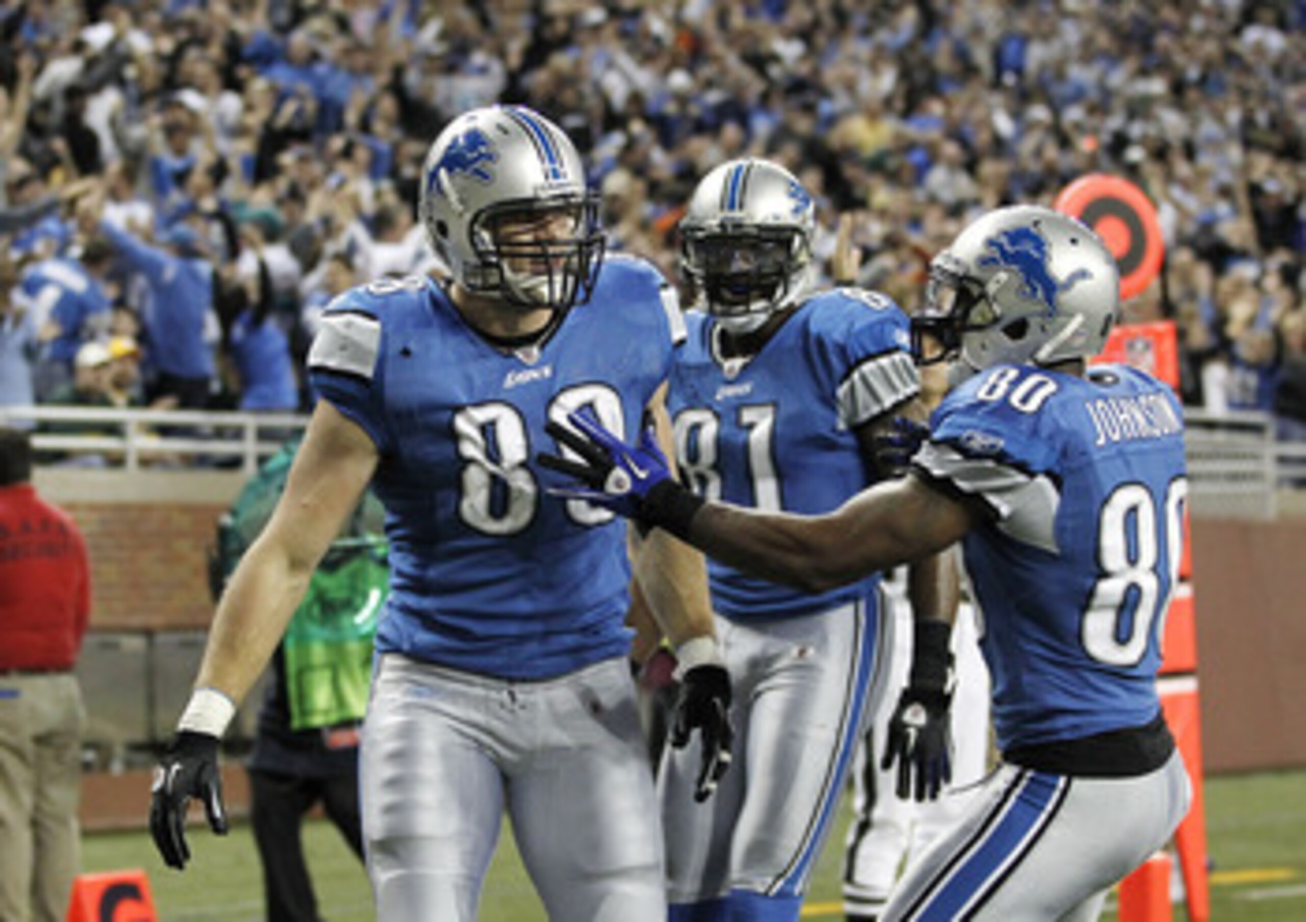 DETROIT, MI - DECEMBER 12:  Will Heller #89 of the Detroit Lions celebrates a for a fourth quarter touchdown with Bryant Johnson #80 and Calvin Johnson #81 while playing the Green Bay Packers on December 12, 2010 at Ford Field in Detroit, Michigan. Detroi