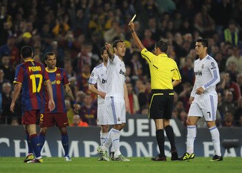 BARCELONA, SPAIN - MAY 03:  Referee Frank De Bleeckere shows the yellow card to Carvalho of Real Madrid (C) during the UEFA Champions League Semi Final second leg match between Barcelona and Real Madrid at the Nou Camp on May 3, 2011 in Barcelona, Spain.