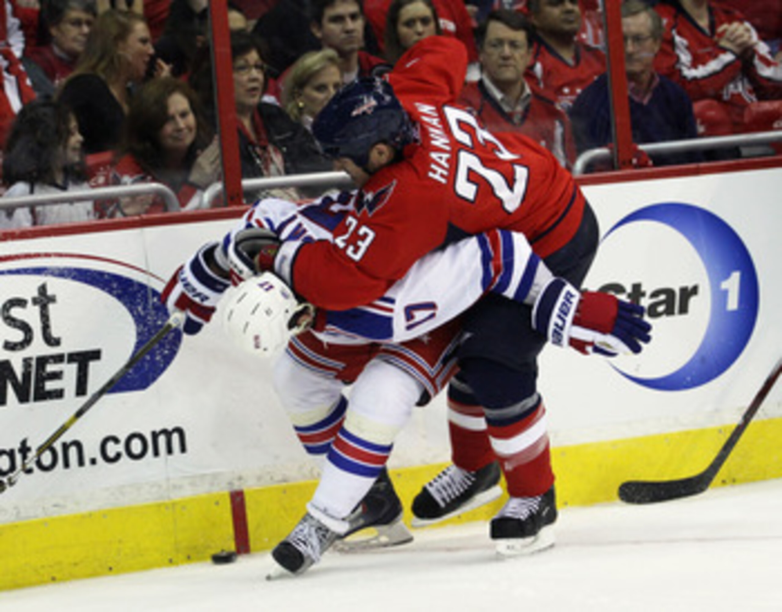 WASHINGTON, DC - APRIL 13:  Scott Hannan #23 of the Washington Capitals hits Brandon Dubinsky #17 of the New York Rangers in Game One of the Eastern Conference Quarterfinals during the 2011 NHL Stanley Cup Playoffs at Verizon Center on April 13, 2011 in W