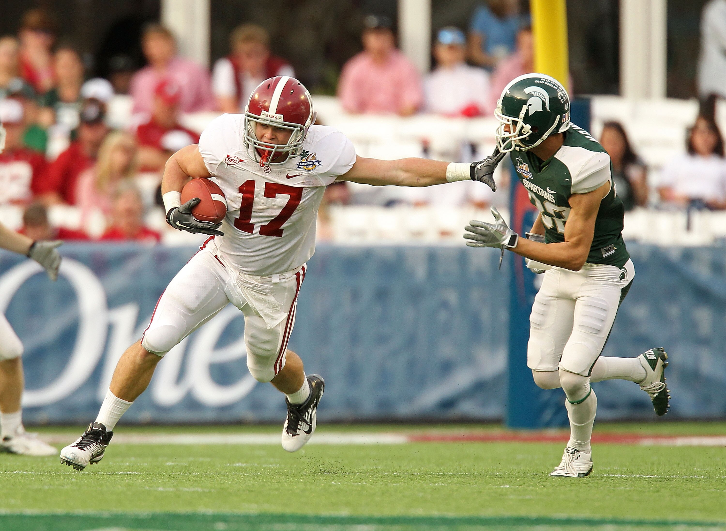 ORLANDO, FL - JANUARY 01: Brad Smelley #17 of the Alabama Crimson Tide runs after a catch stiffarming Josh Bodell #22 of the Michigan State Spartans during the Capitol One Bowl at the Florida Citrus Bowl on January 1, 2011 in Orlando, Florida.  (Photo by