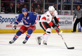 NEW YORK - MARCH 22: Daniel Alfredsson #11 of the Ottawa Senators skates with the puck in front of Chris Drury #23 of the New York Rangers on March 22, 2009 at Madison Square Garden in New York City, New York.  (Photo by Nick Laham/Getty Images)